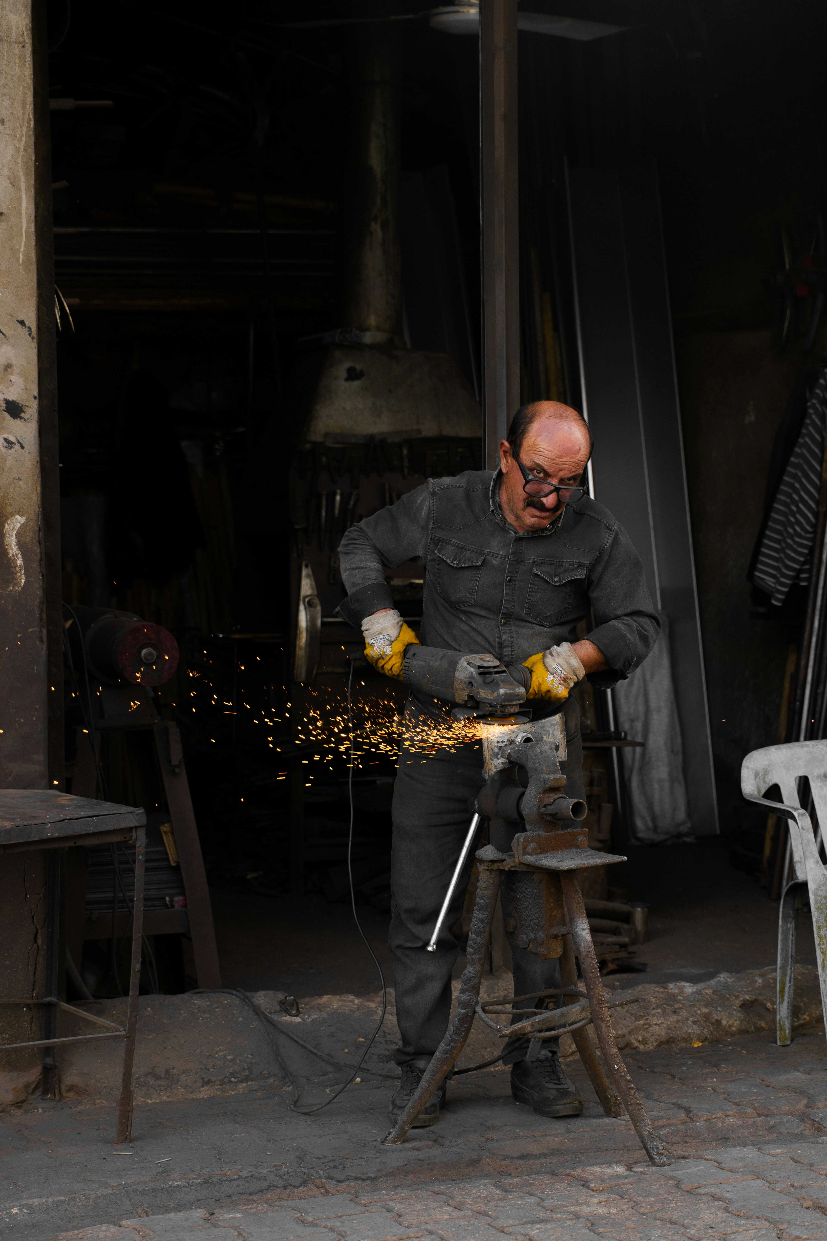 Homem triturando metal com faíscas voando