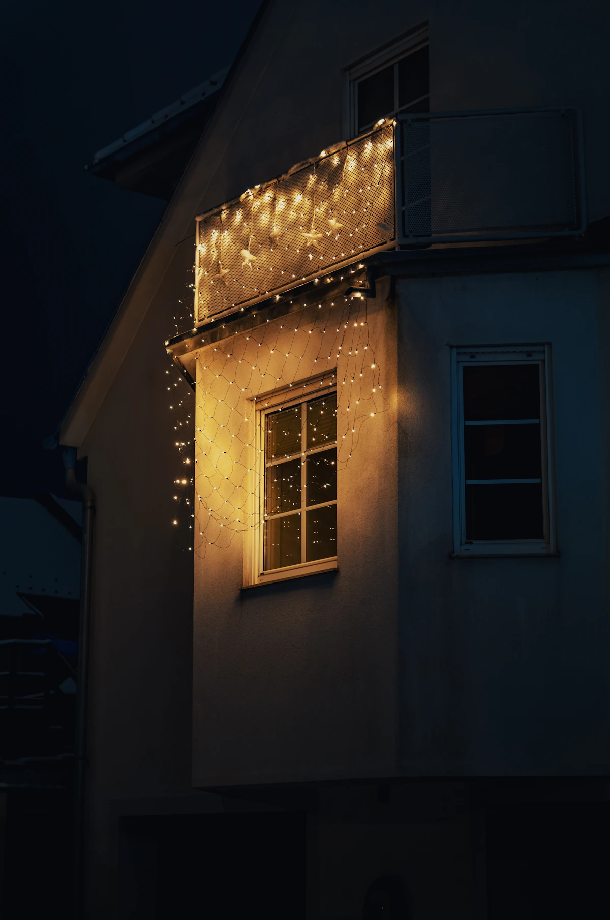 House illuminated by warm permanent LED string lights at night