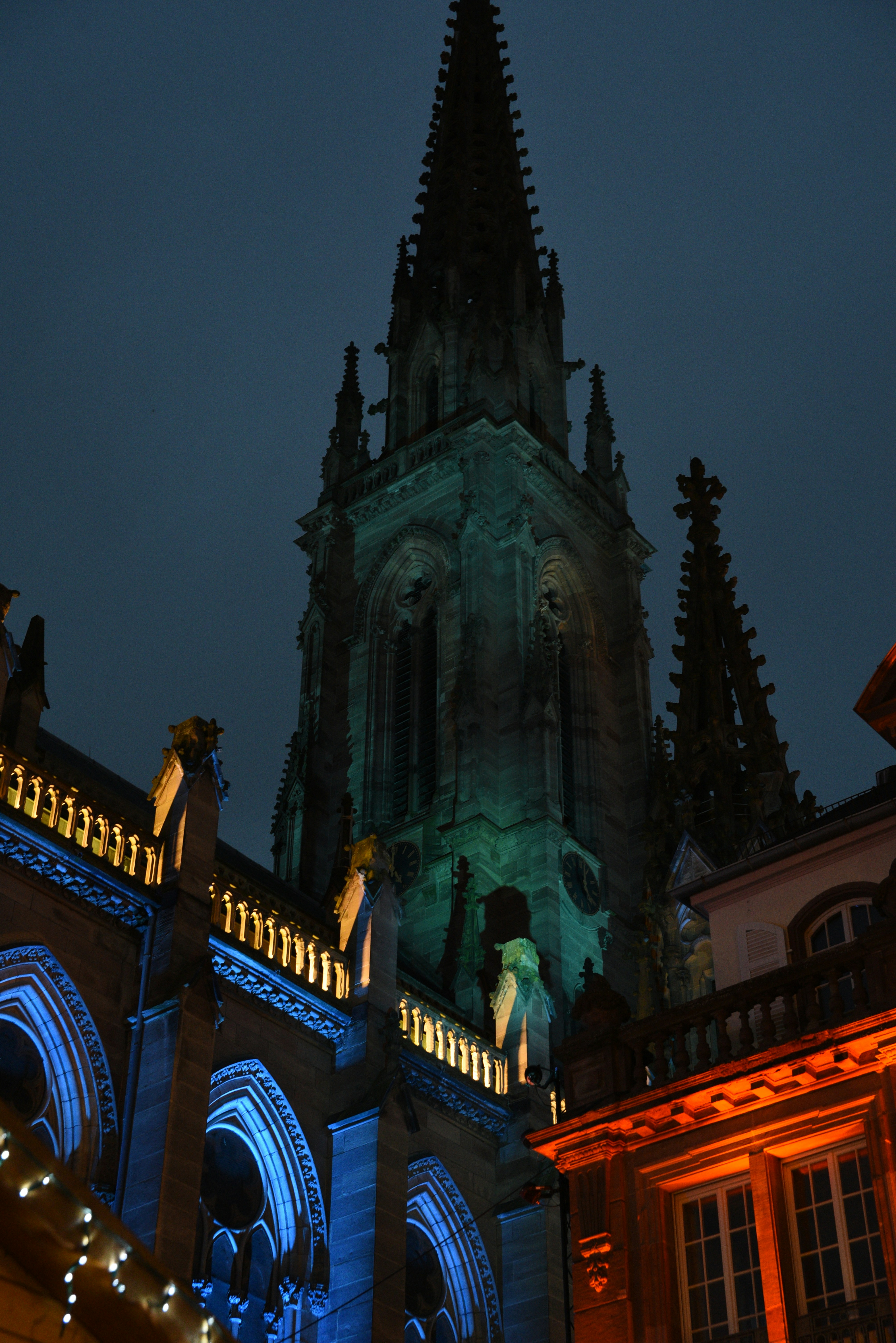 Gothic cathedral illuminated with colorful lights at night.