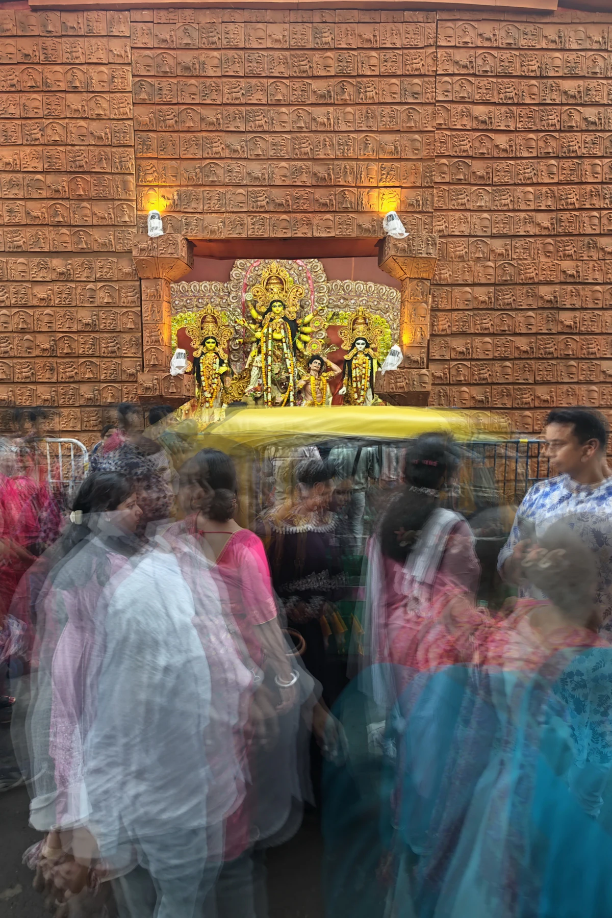 People gathered in front of a Durga idol during a procession
