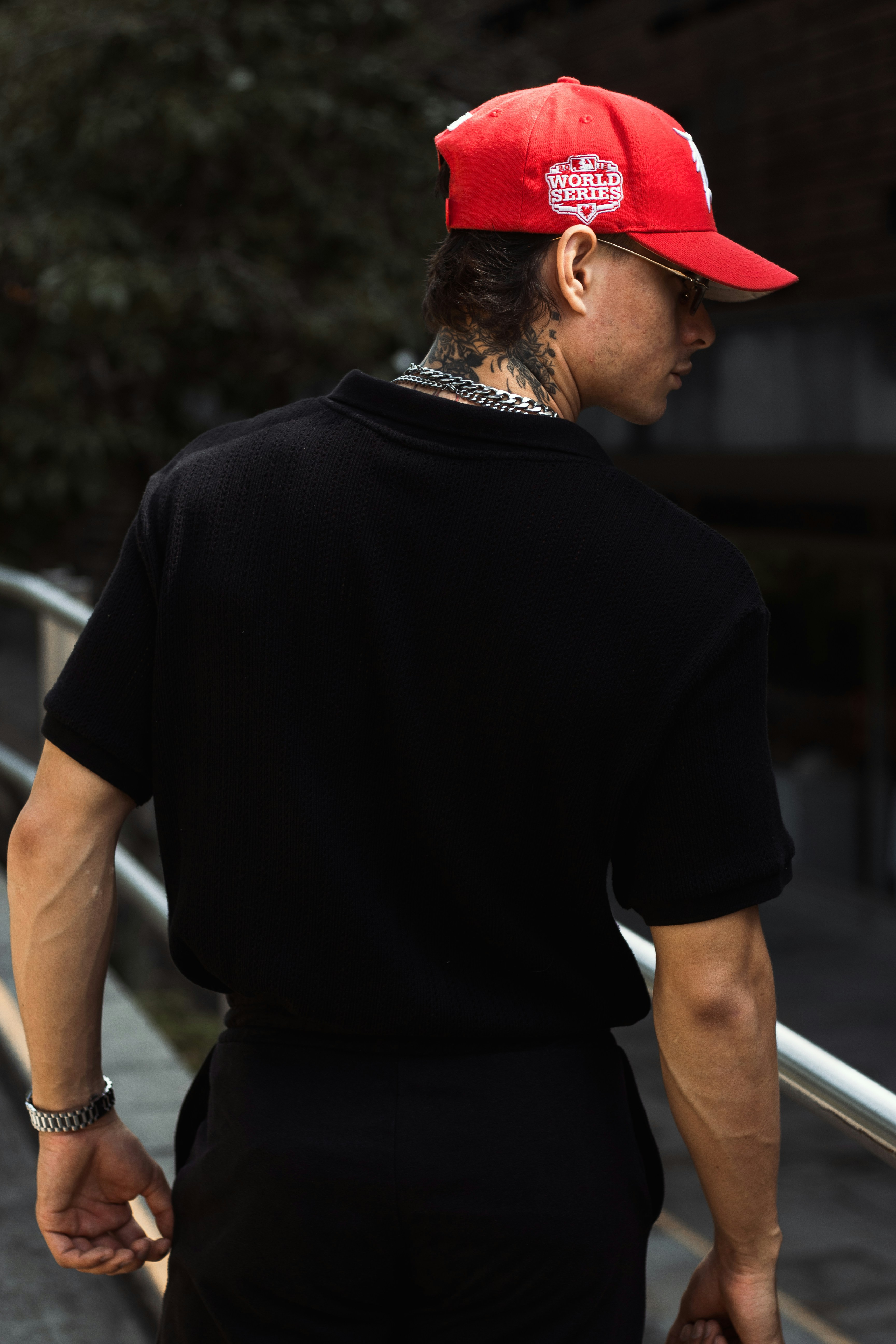 Man in red cap and black shirt walking outside