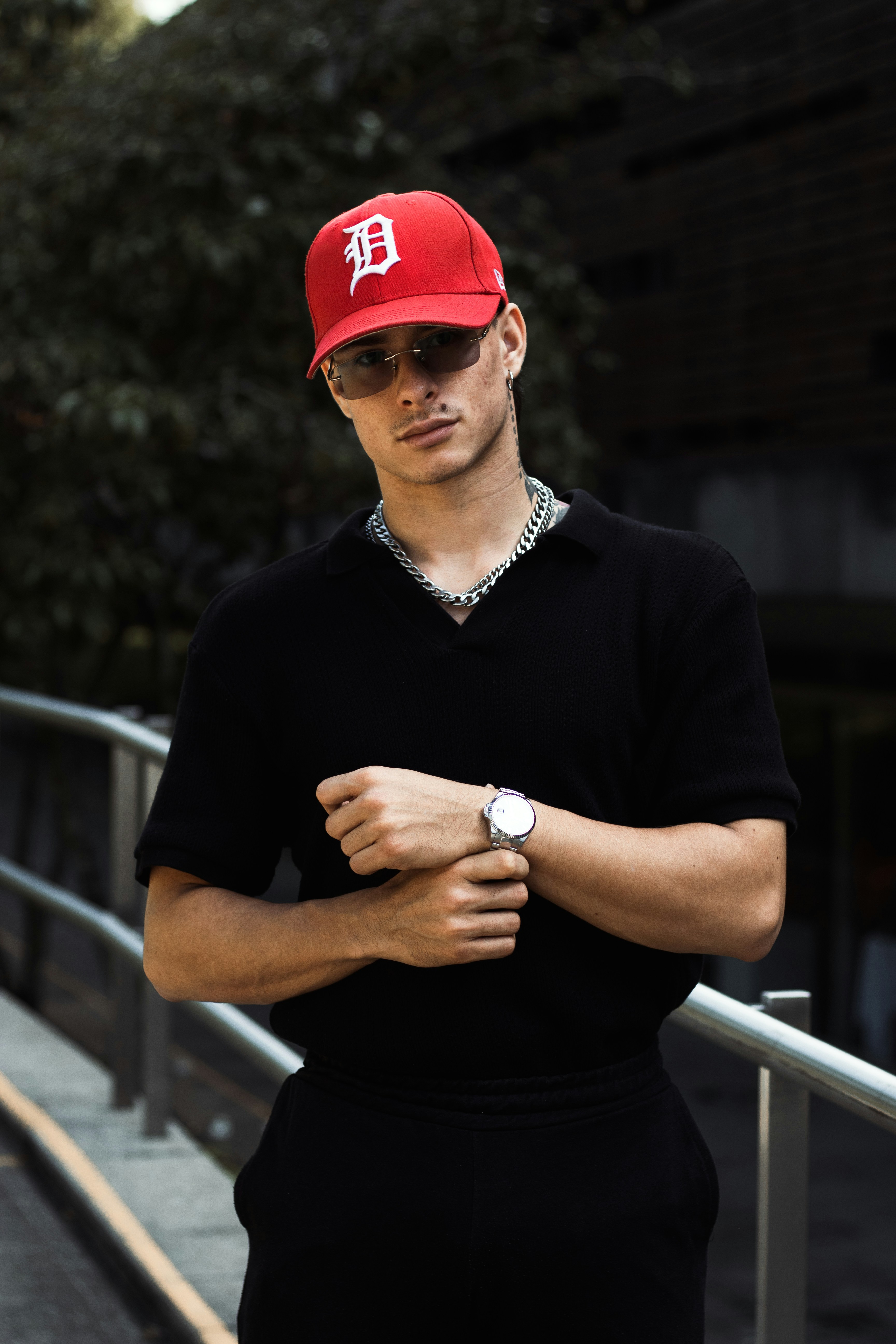 Man in red cap and black shirt adjusts watch