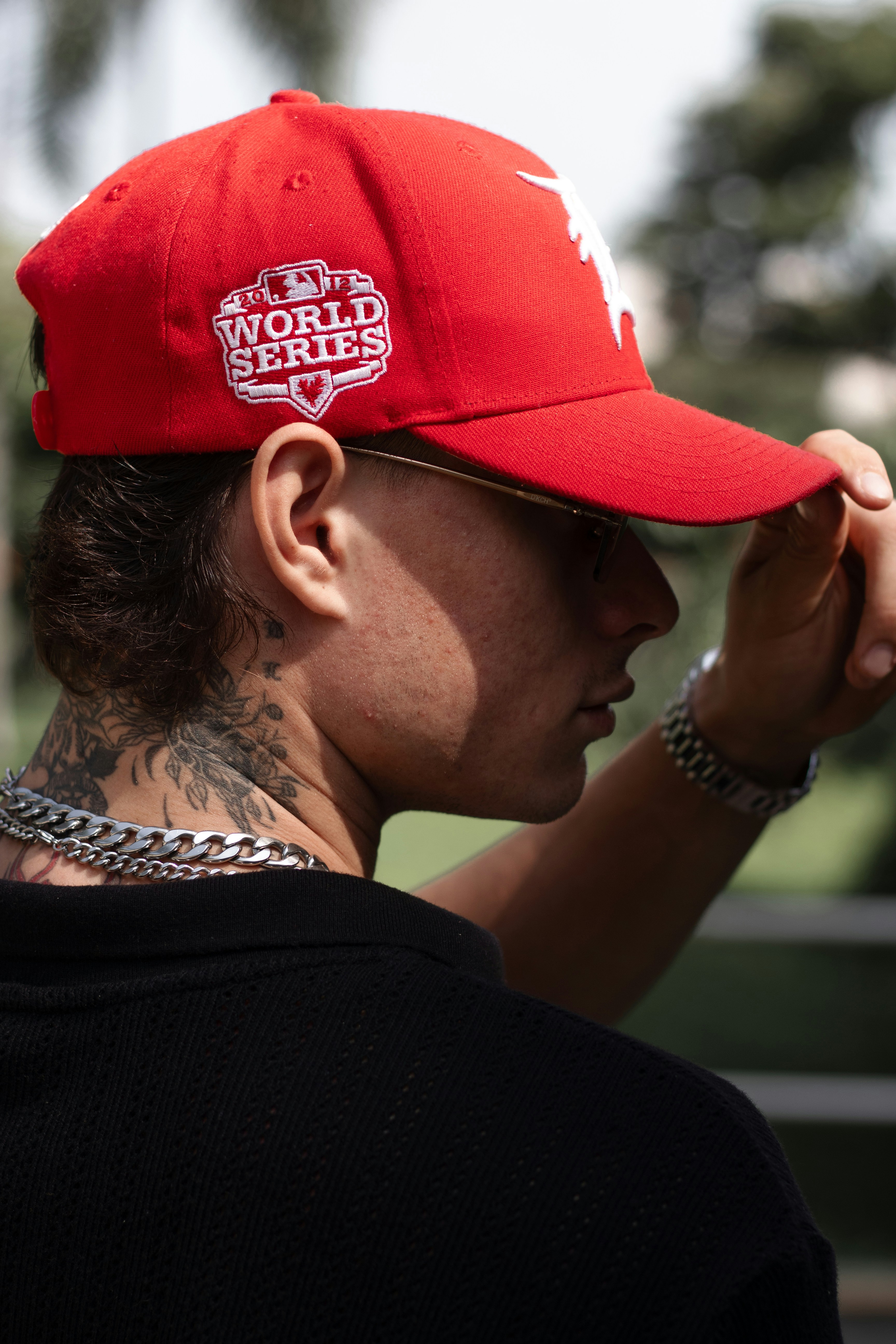 Man wearing a red baseball cap with world series patch.