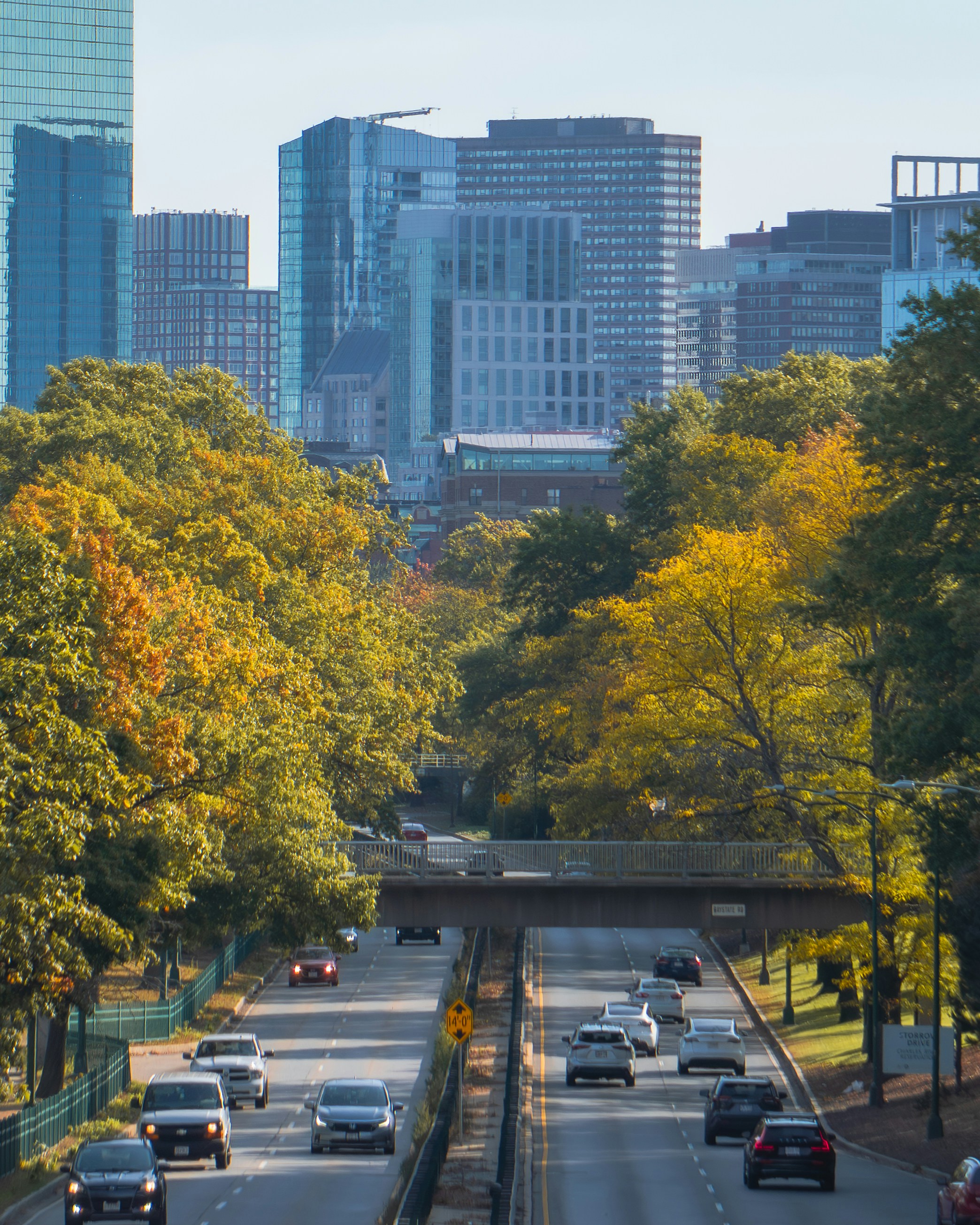 Coches circulando por una autopista con edificios de la ciudad de fondo.