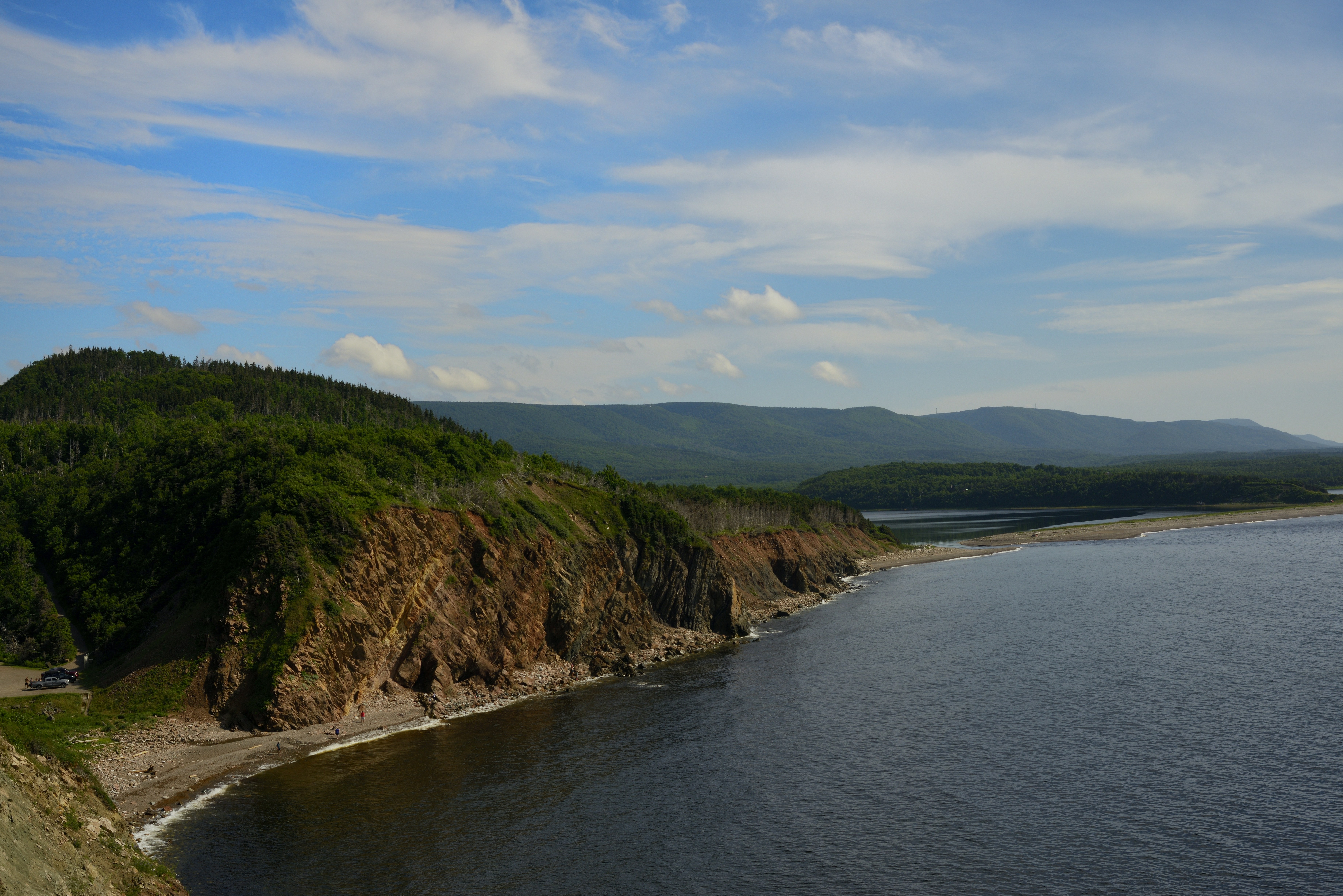 Rocky coastline with lush green forest and blue sky