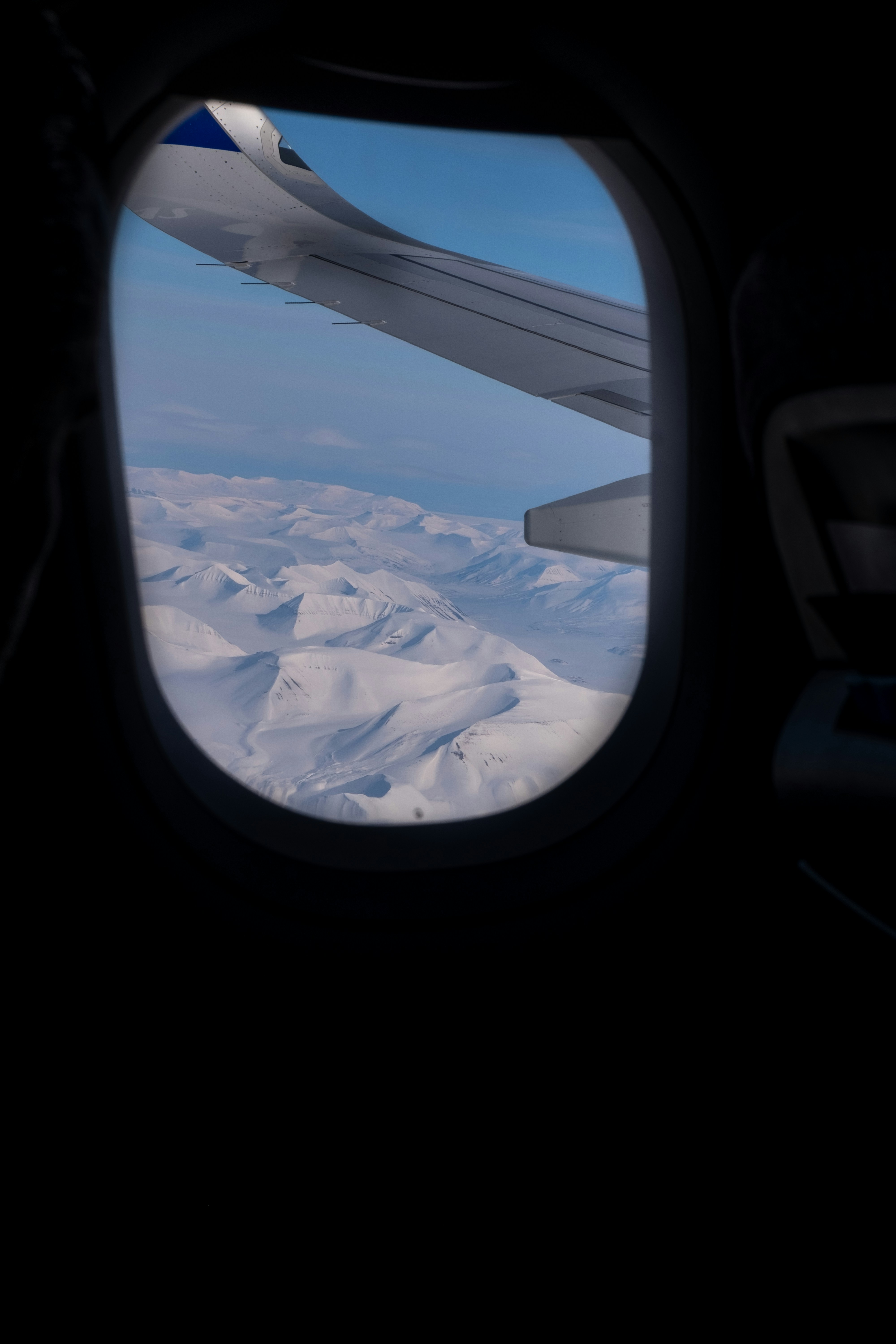 Snowy mountains seen through airplane window