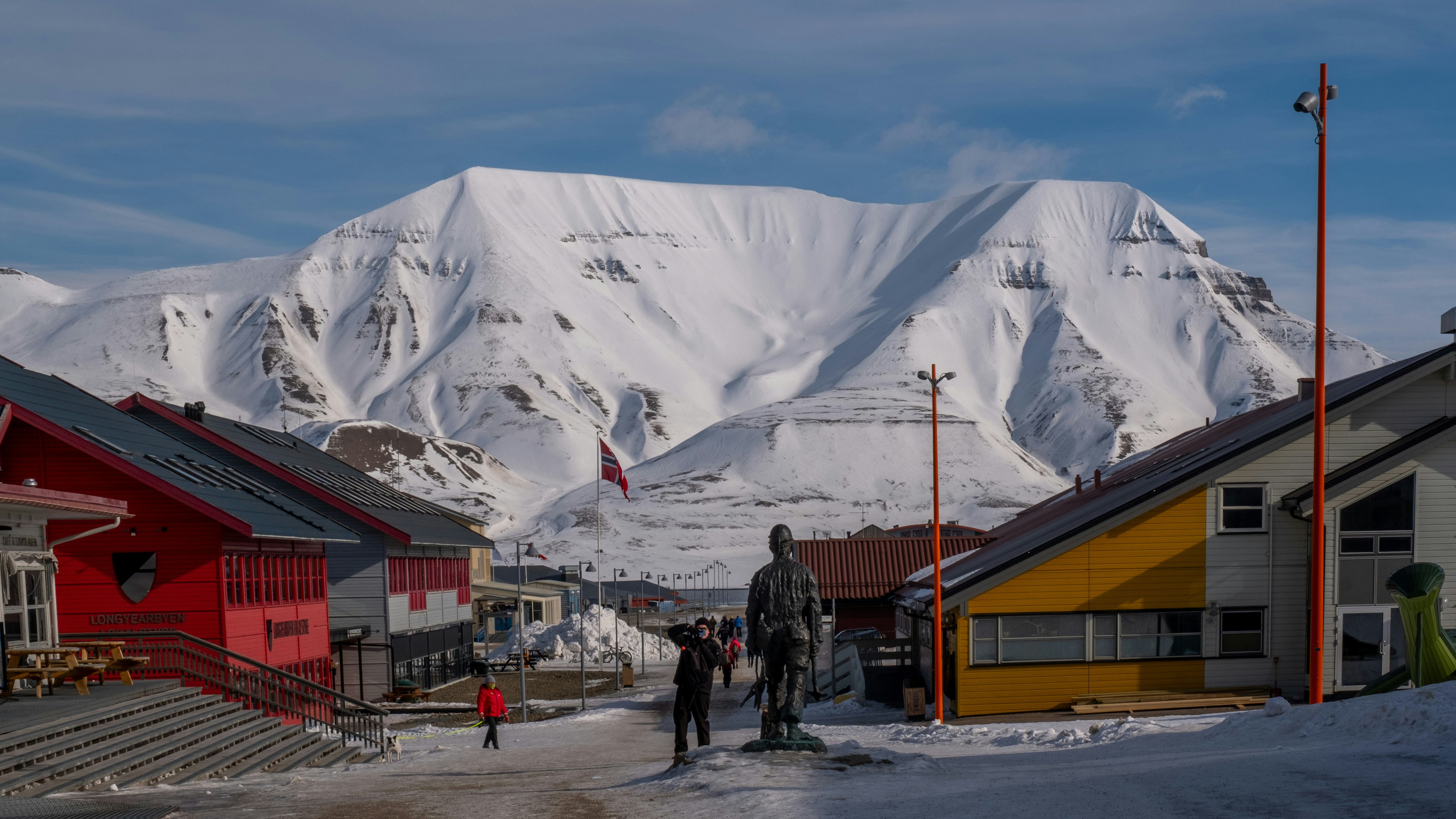 Colorful buildings in snowy town with mountain backdrop.