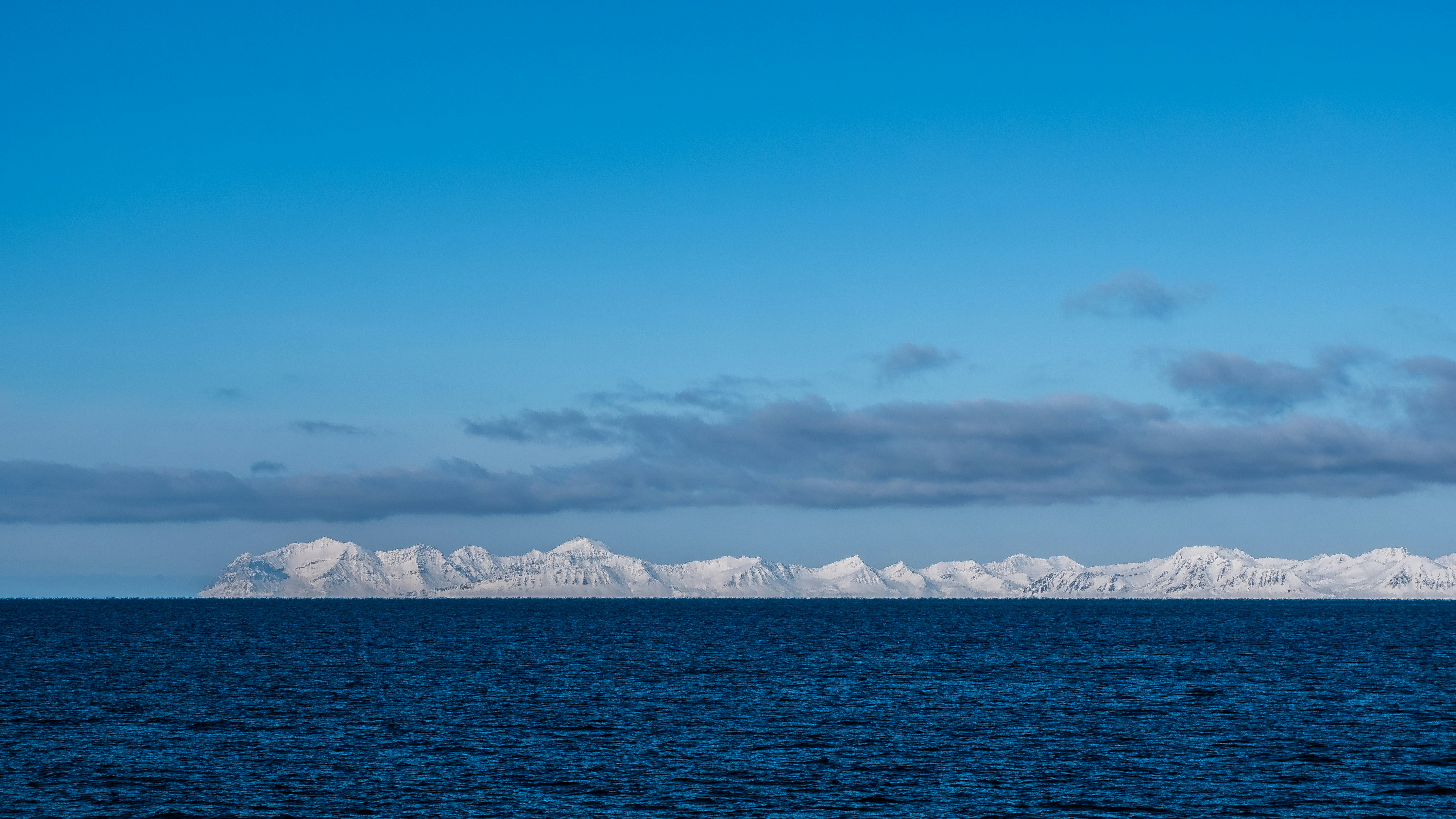Iceberg formations on the horizon under a blue sky