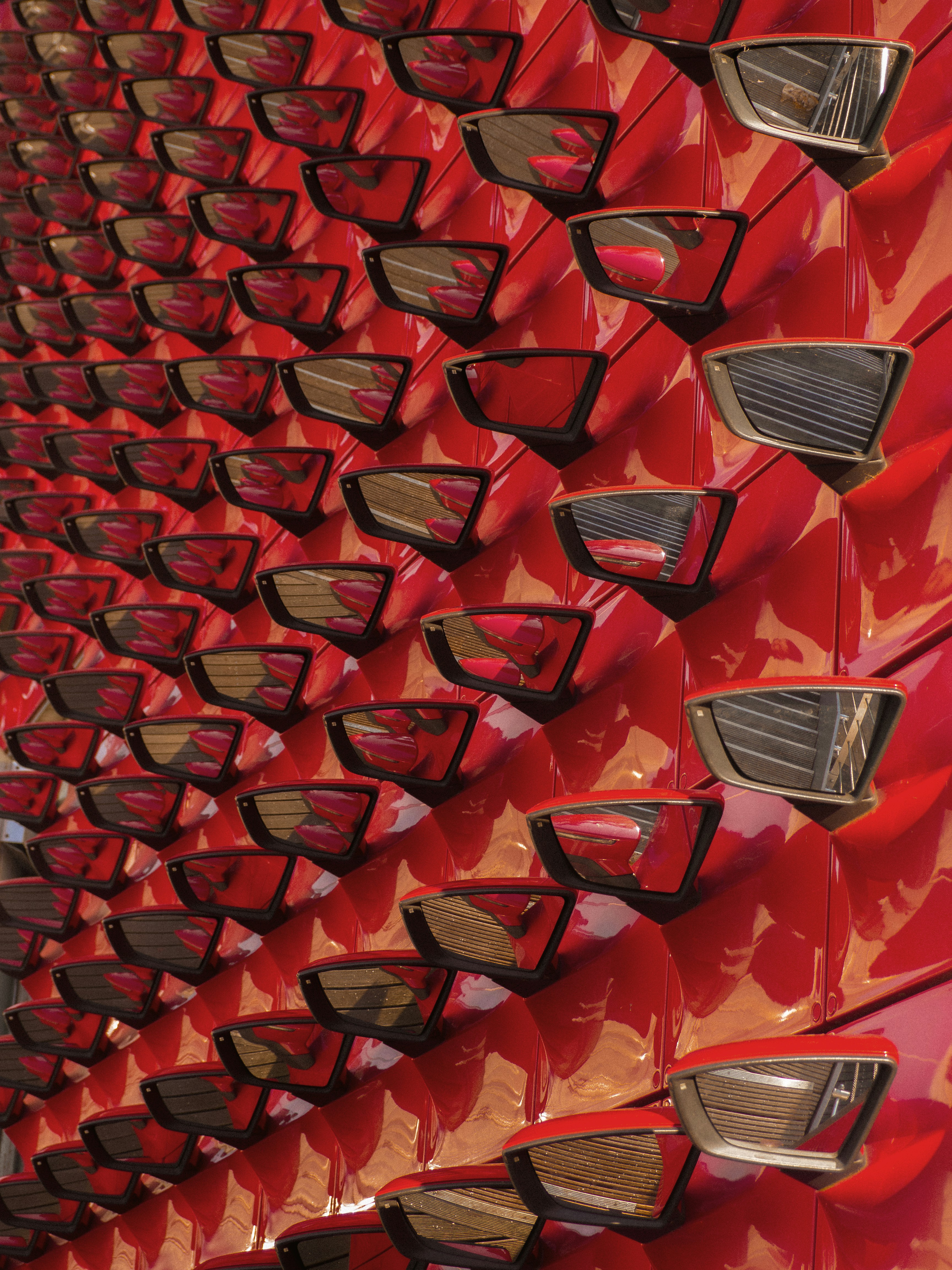 Rows of red sunglasses displayed on a wall.