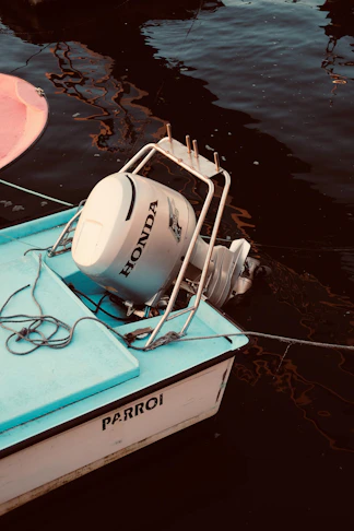 Small boat with honda outboard motor docked.