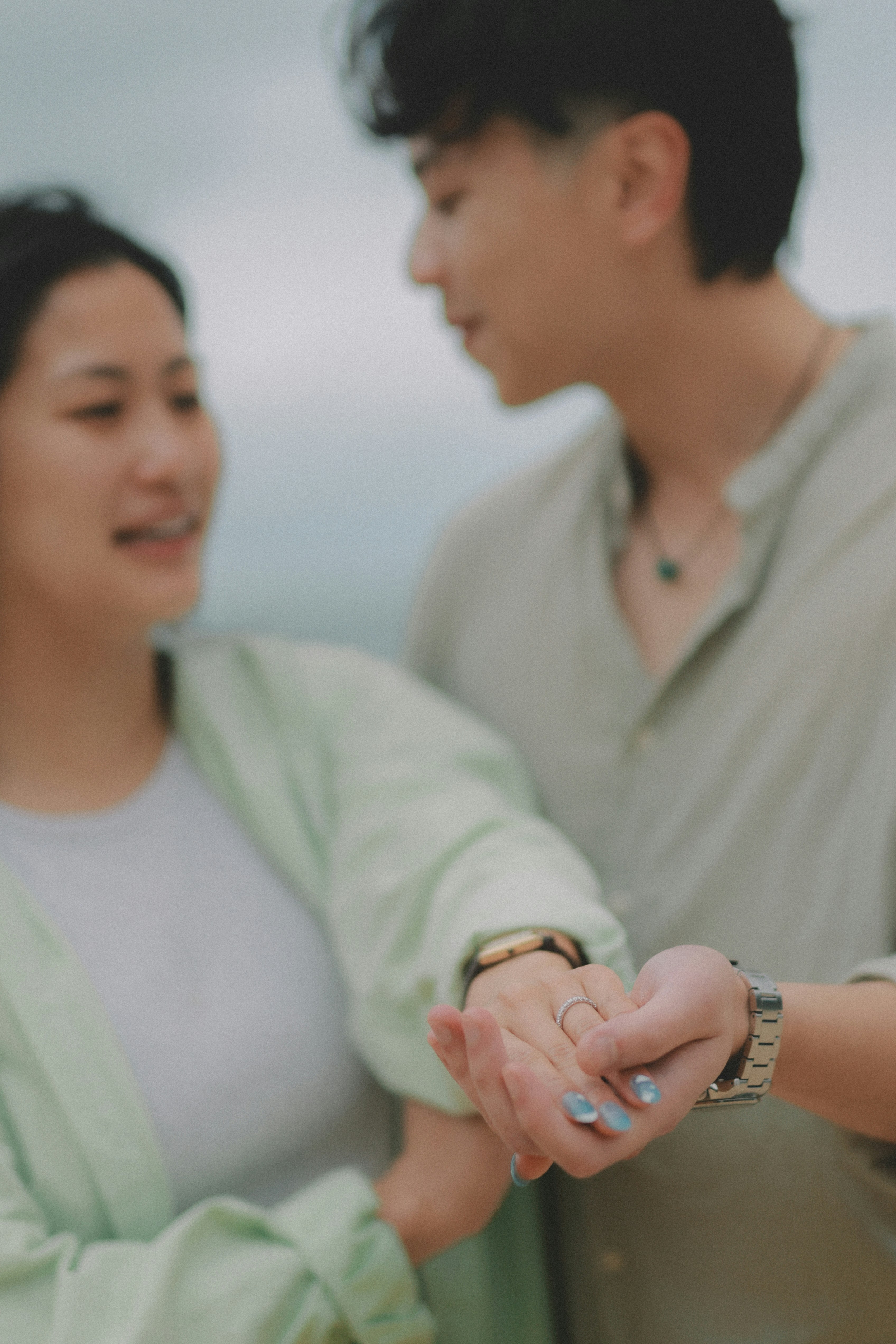 Pareja cogida de la mano, mostrando anillos