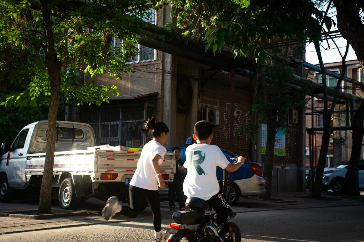 Children playing on a street near a parked truck during a community service project in a neighborhood.