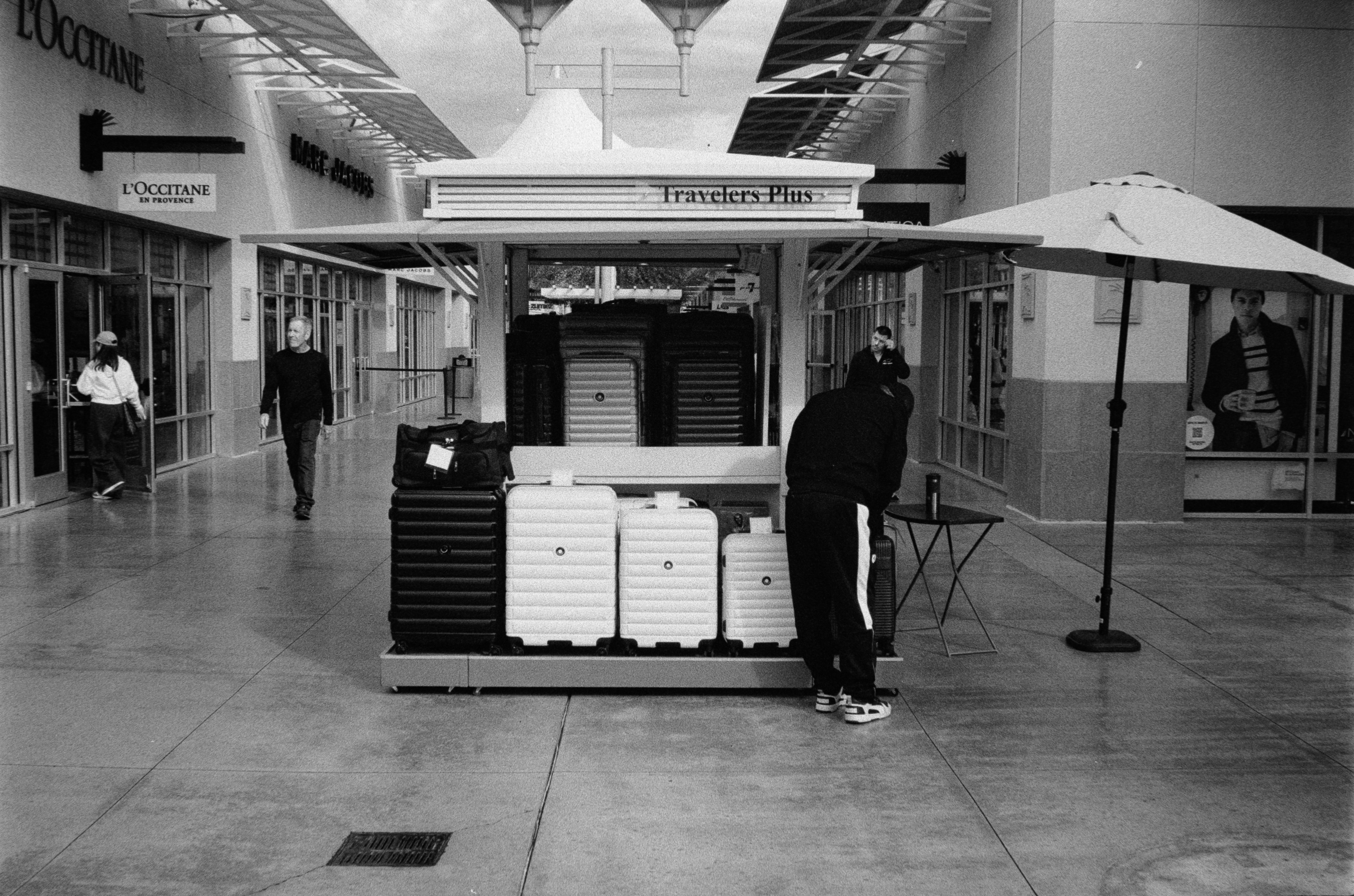 People walk past a kiosk in a shopping mall.