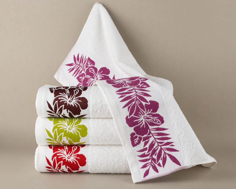 Folded white towels with embroidered floral borders