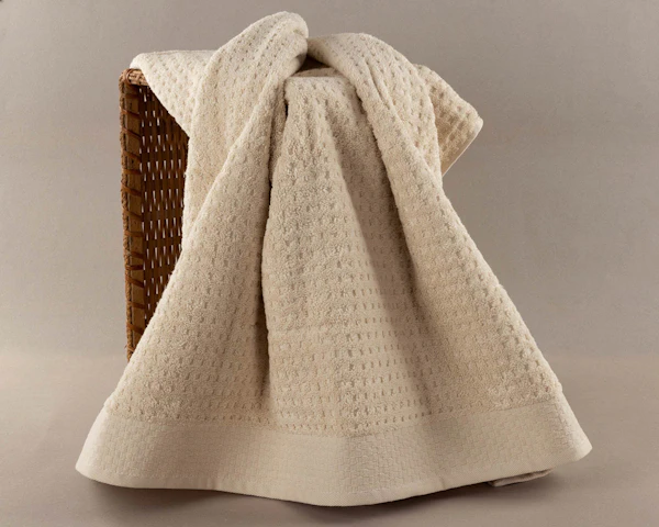 Folded white spa towels in a warm bathroom setting