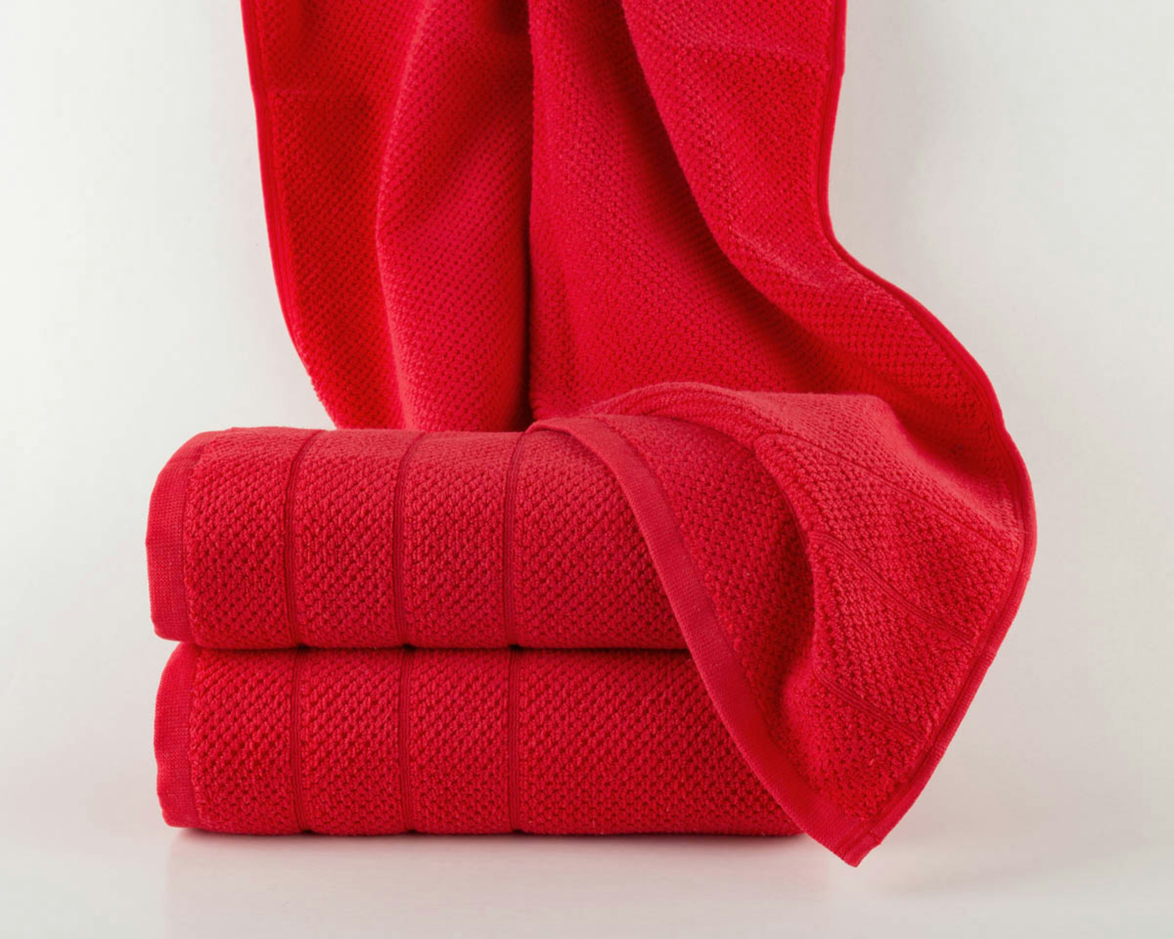 Two folded red towels with one draped