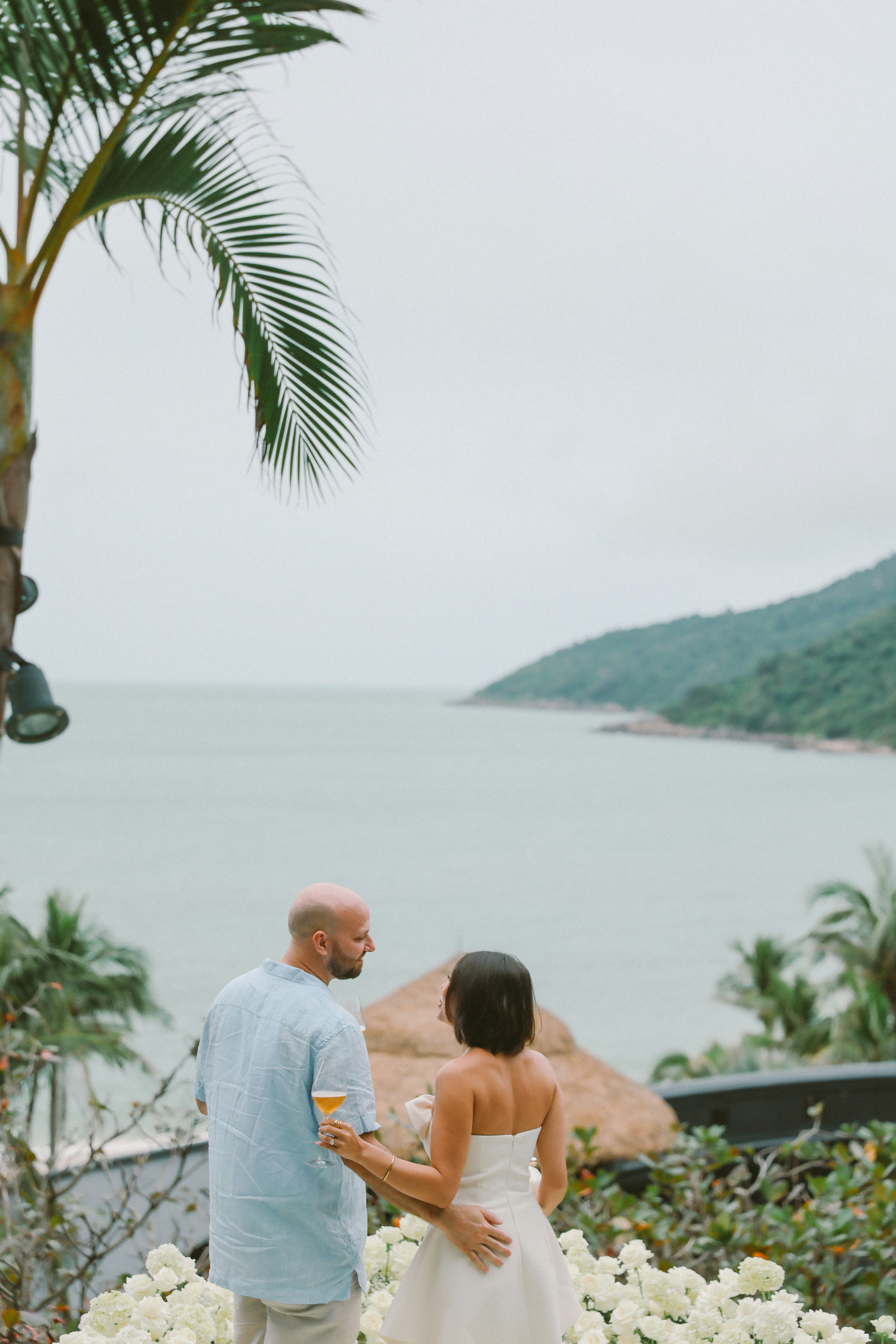 Couple admires ocean view from tropical balcony