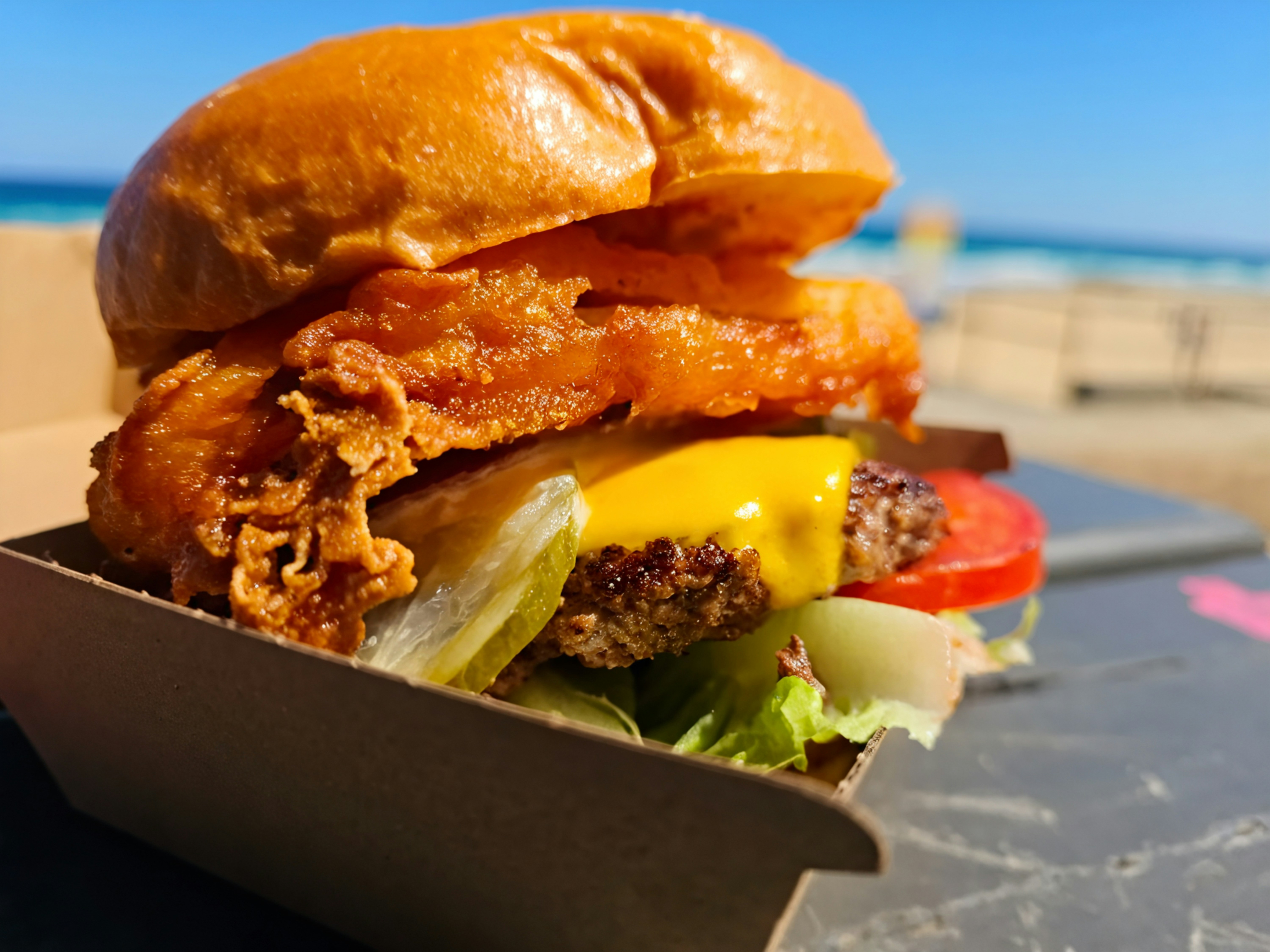 A delicious burger with onion rings and cheese.