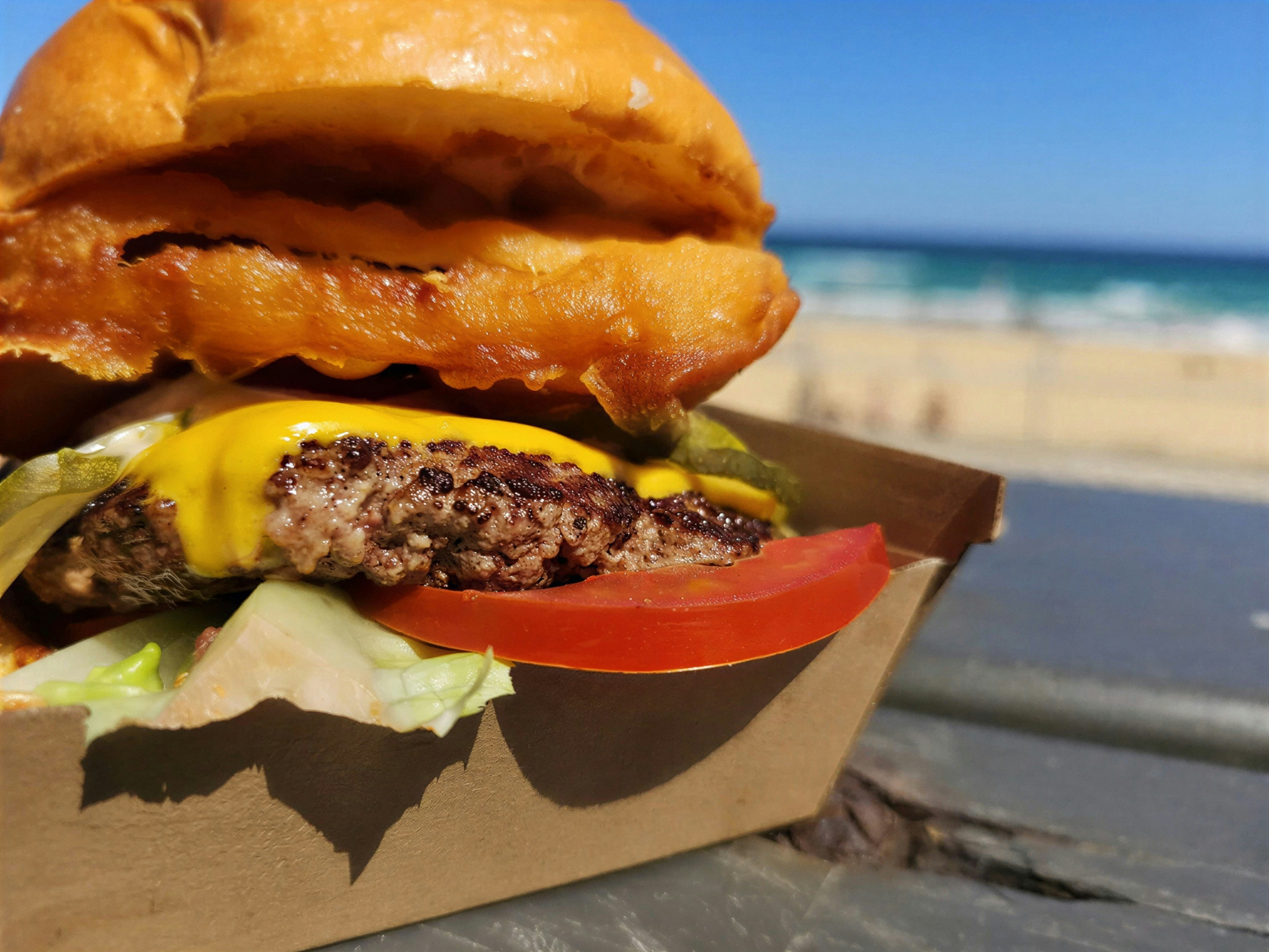 Cheeseburger with lettuce, tomato, and pickles on bun