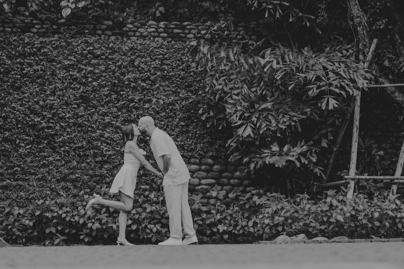 Gay couple kissing in front of green wall