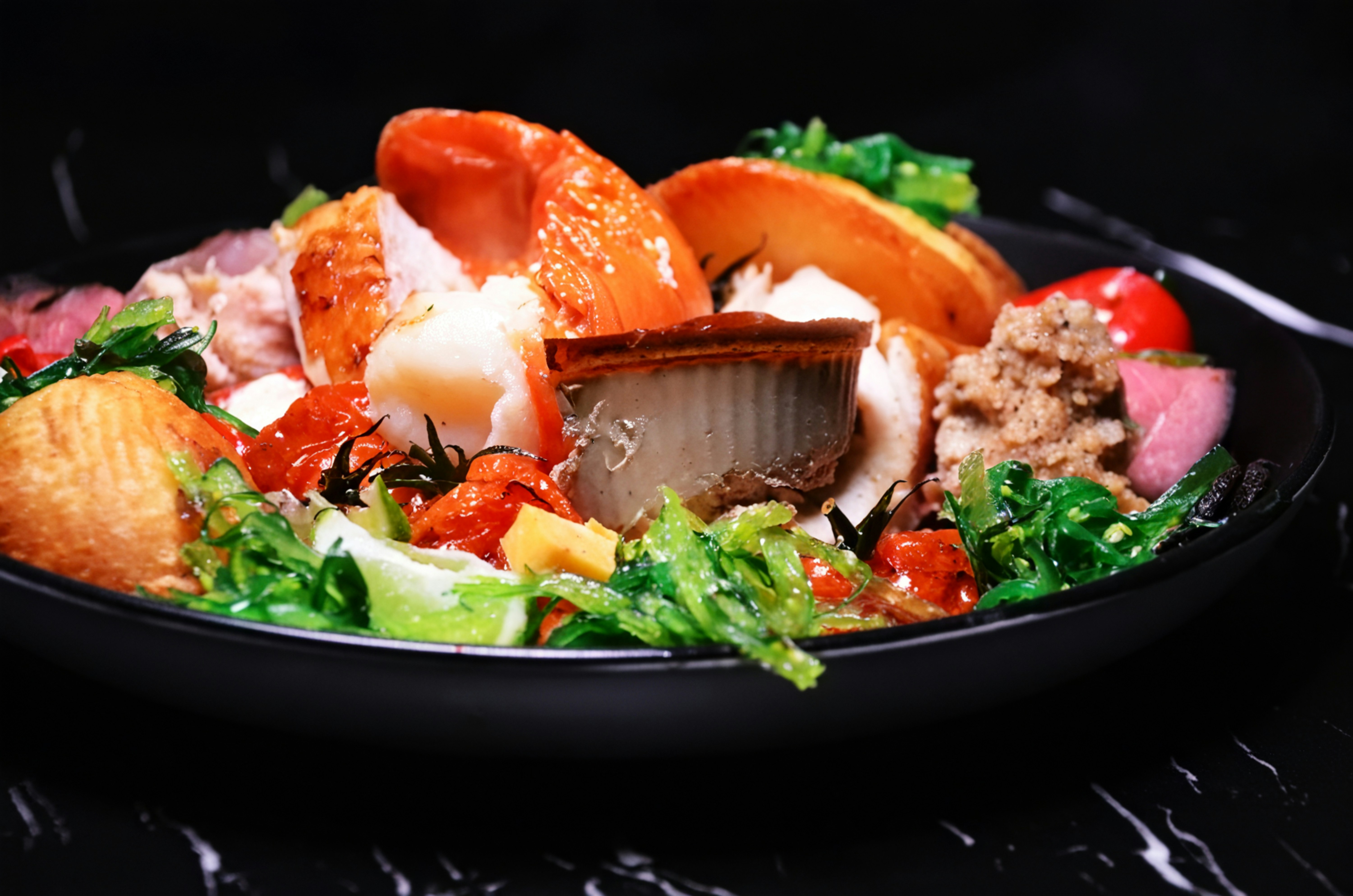 A delicious seafood and meat platter with fresh greens.