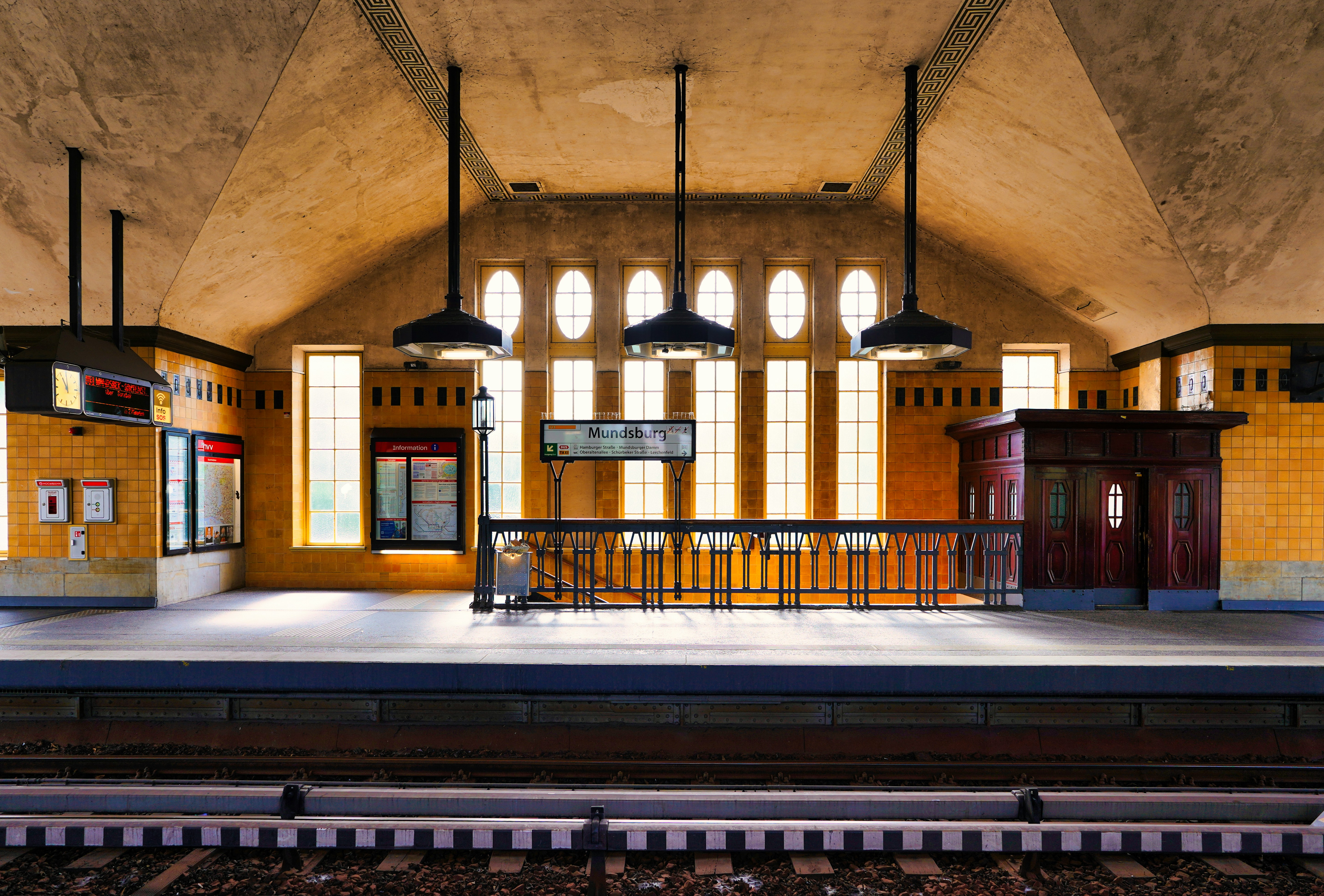 An empty subway station with arched ceiling and lights.