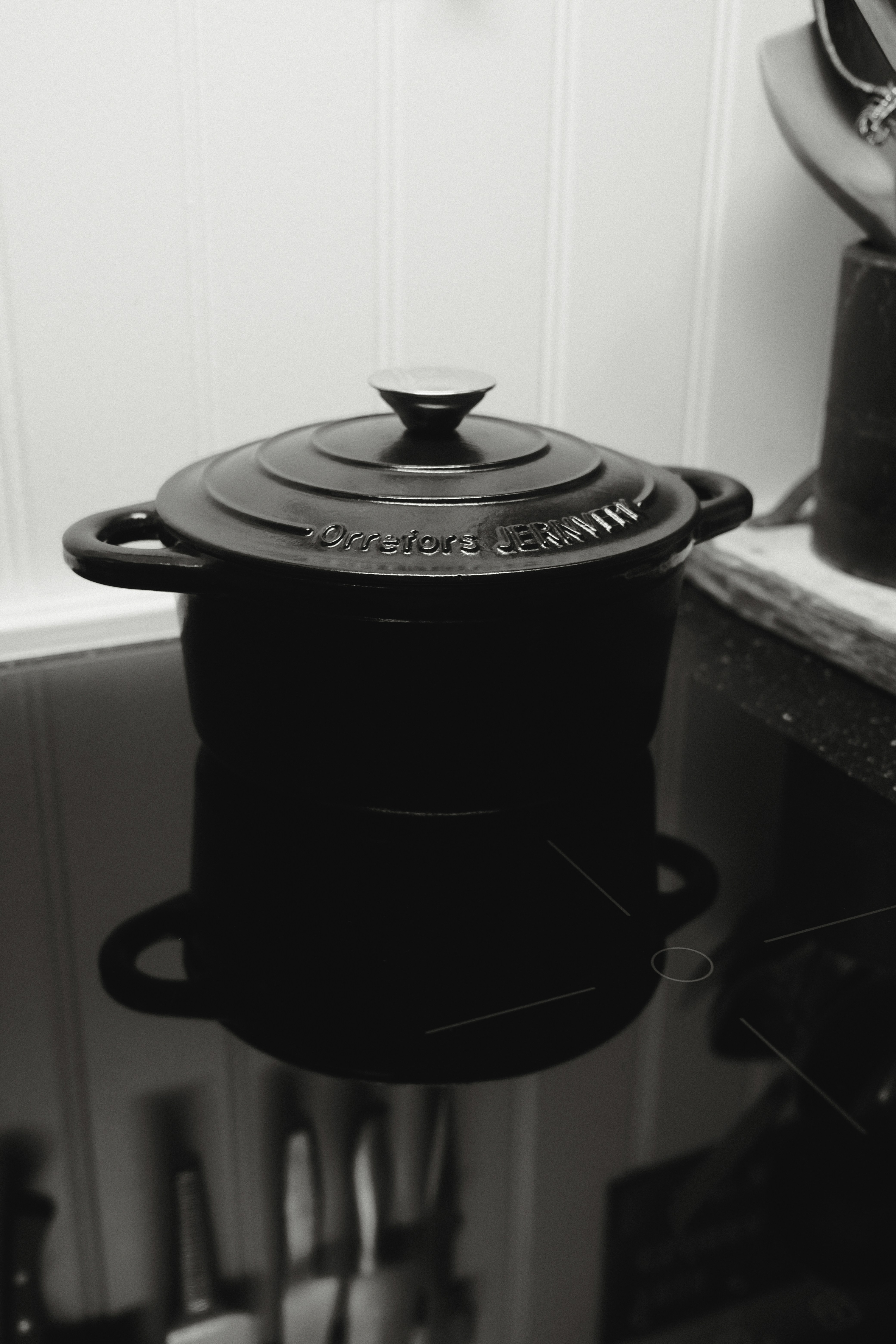 Black cast iron pot with lid on stovetop.