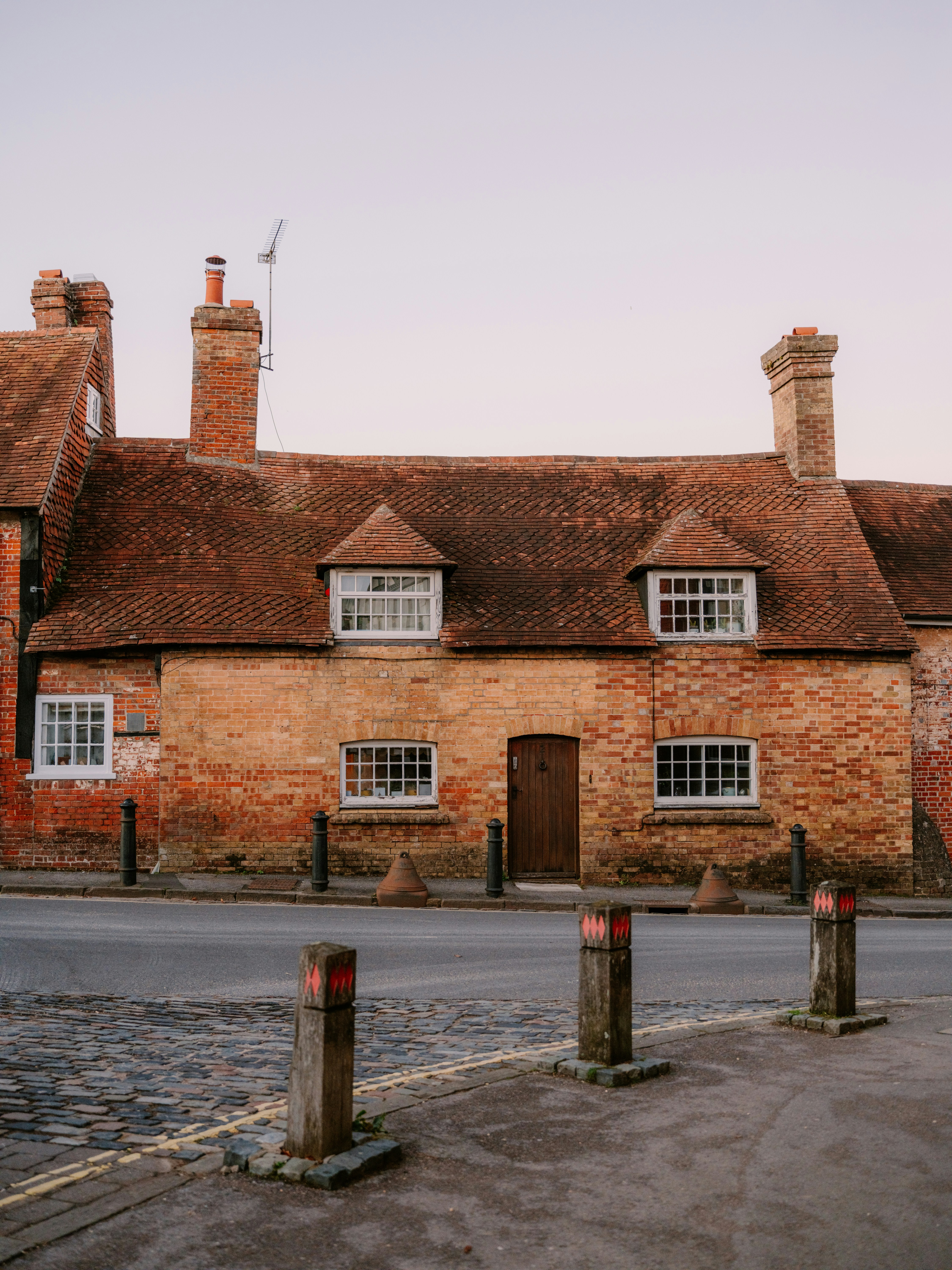 Old brick cottage with a tiled roof and dormer windows.