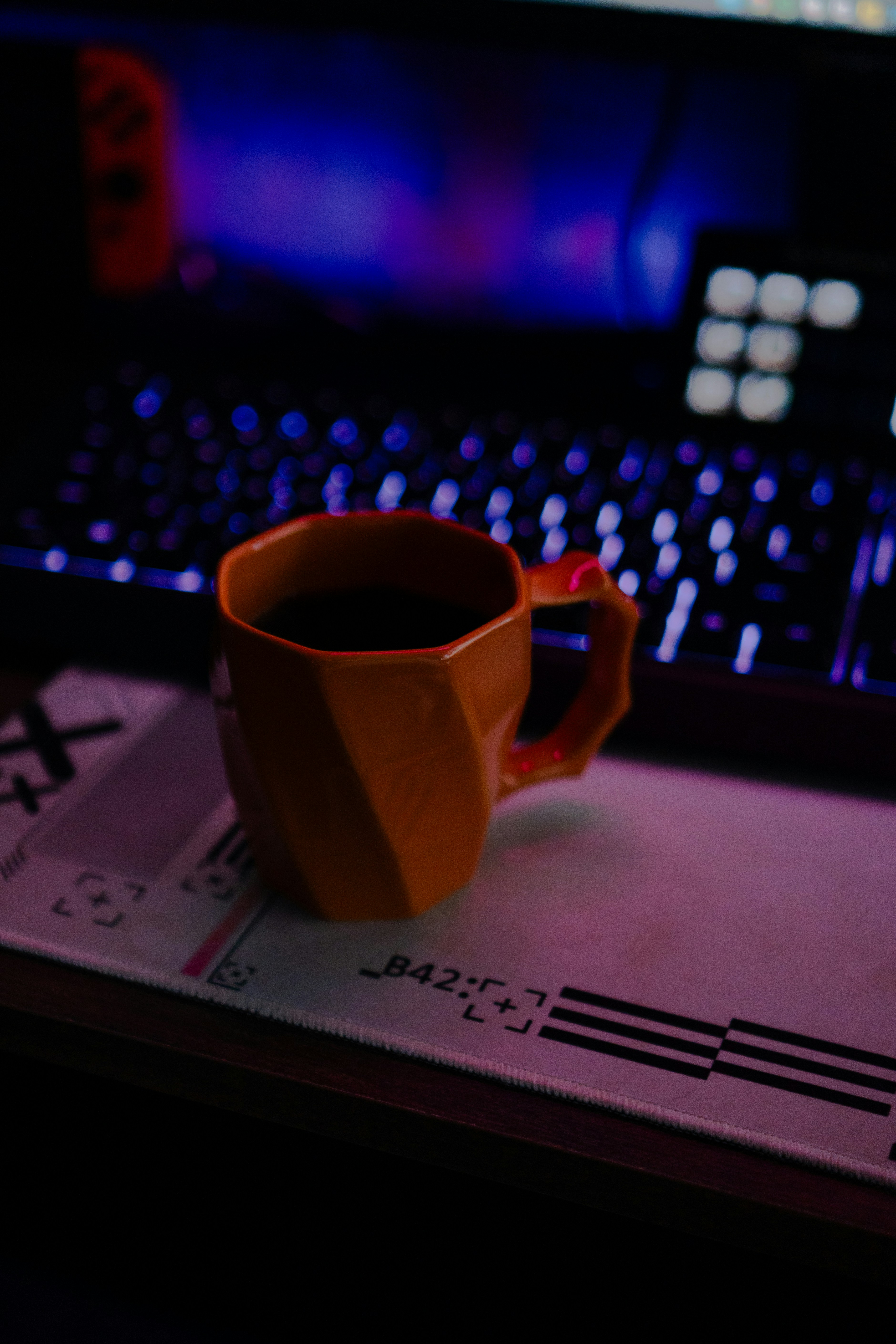 Orange mug filled with dark liquid on desk