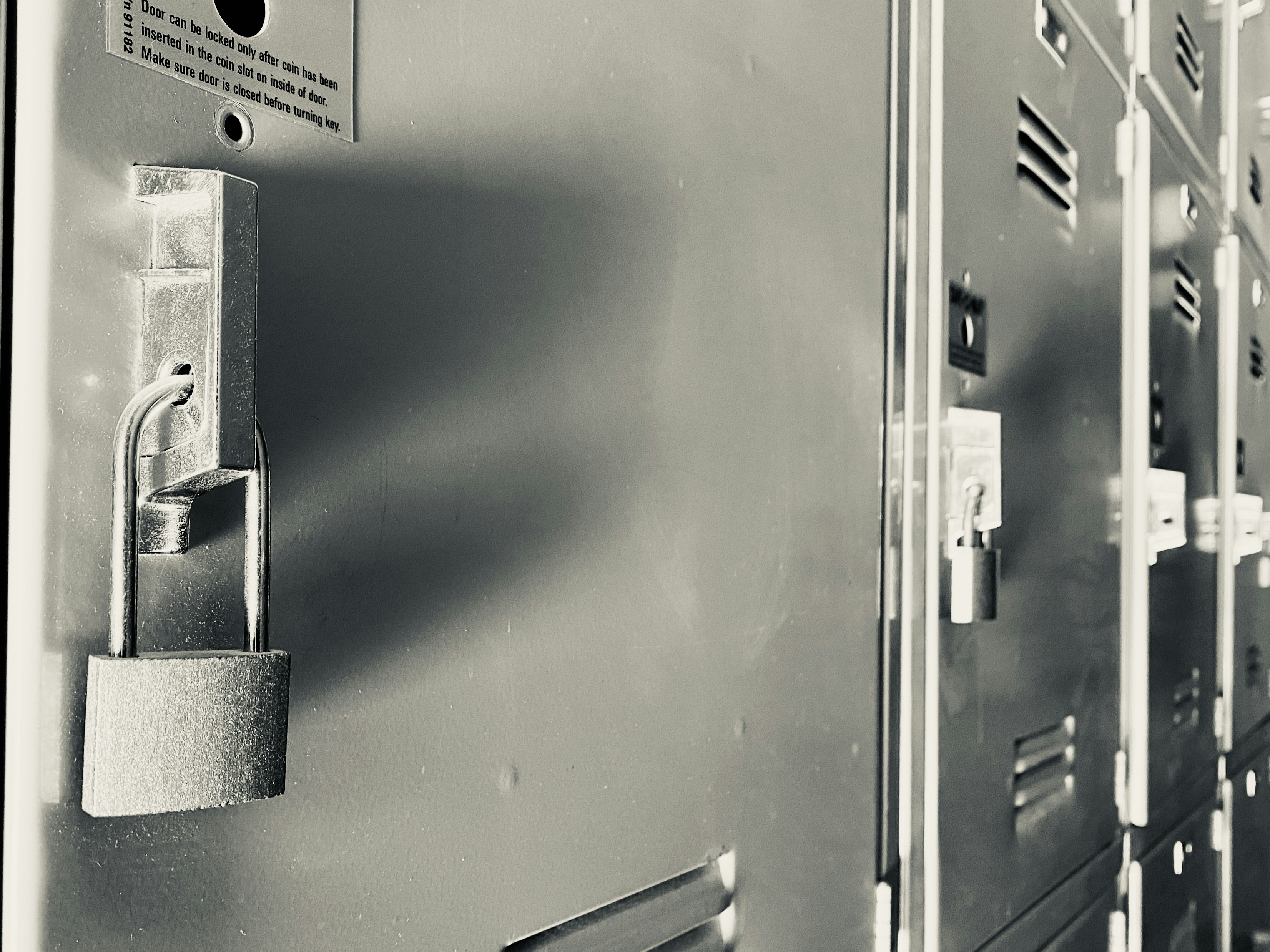 Row of metal lockers with padlocks on doors
