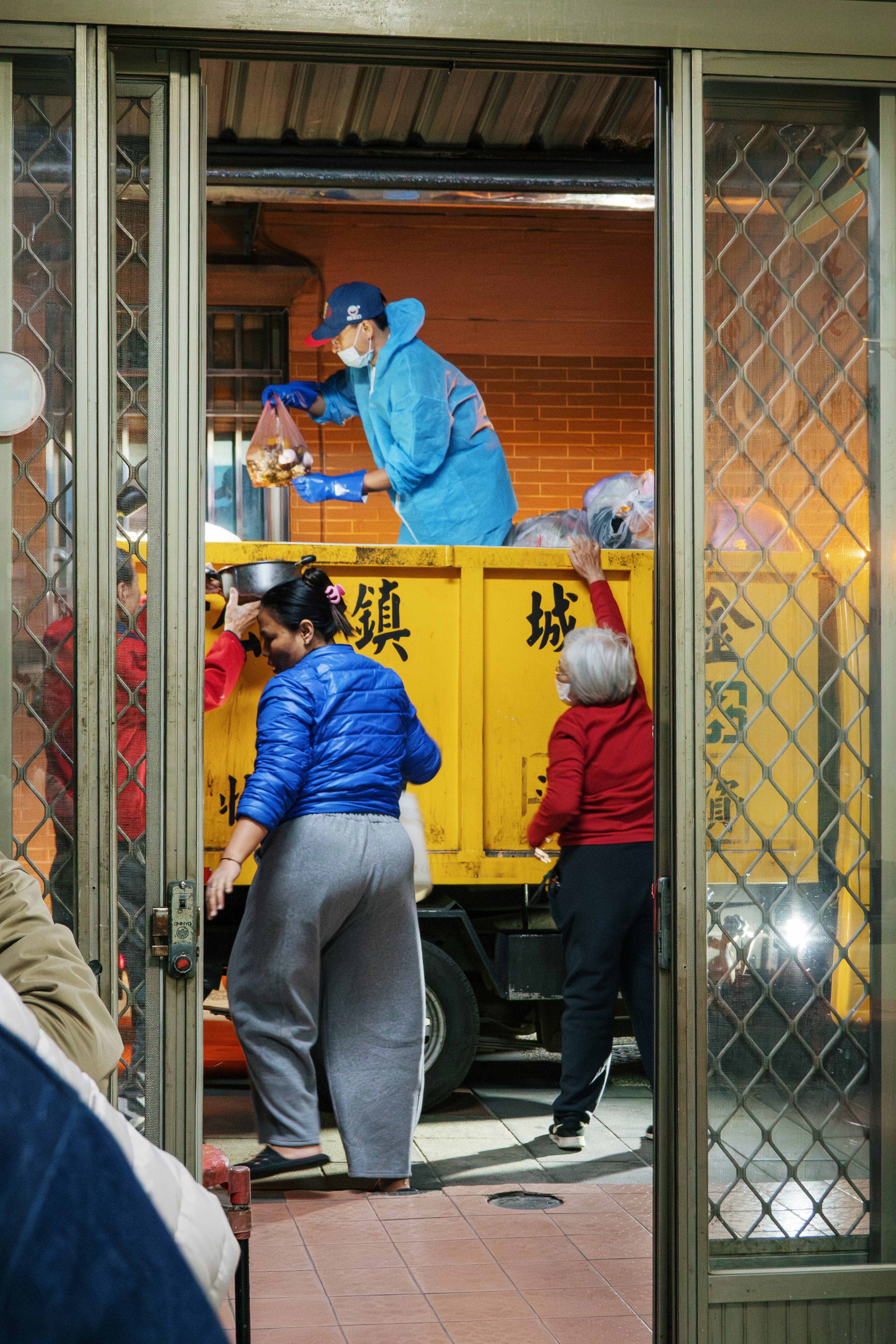 People loading supplies into a yellow truck.