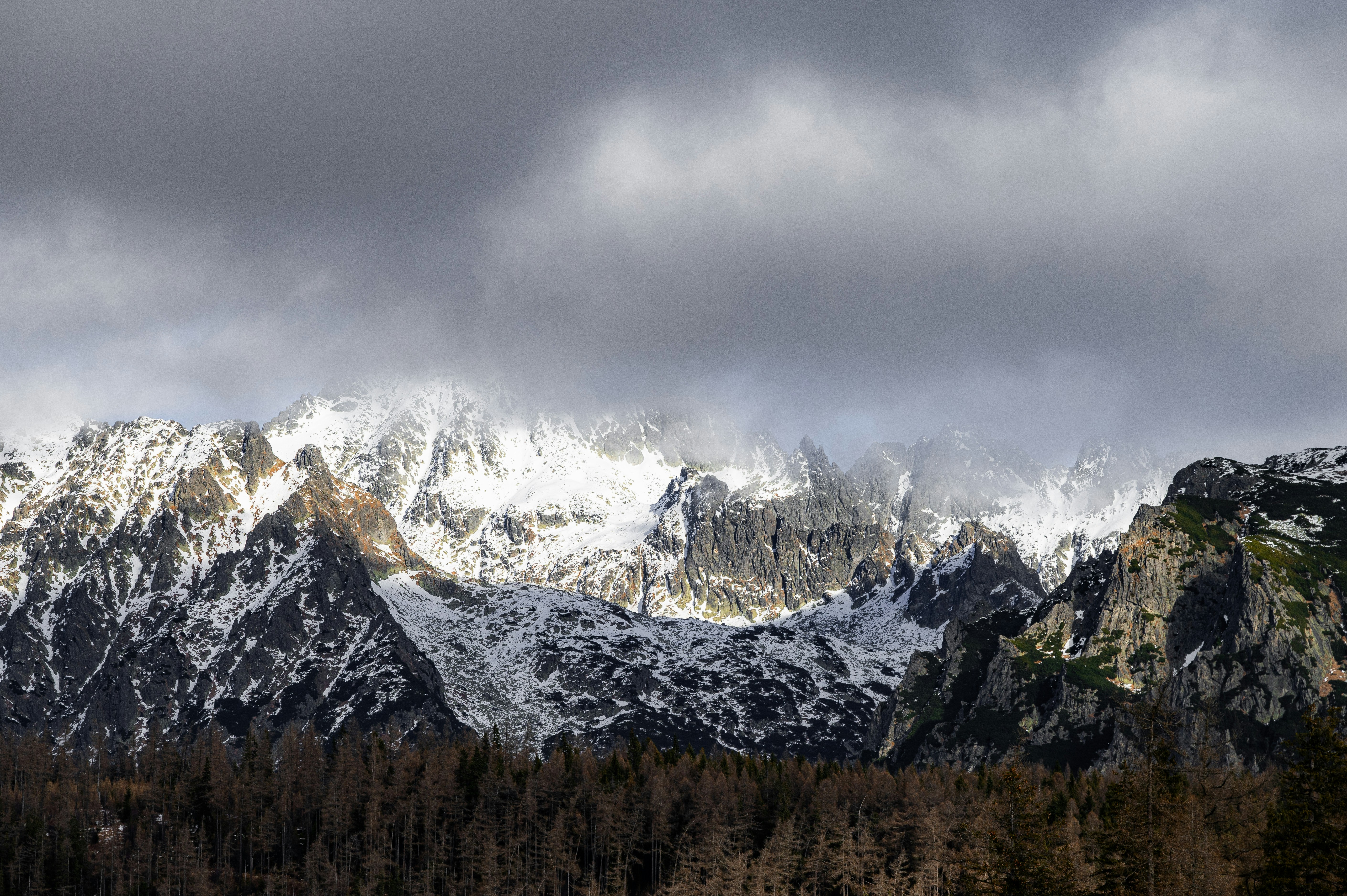 Snow-covered mountains under dramatic clouds