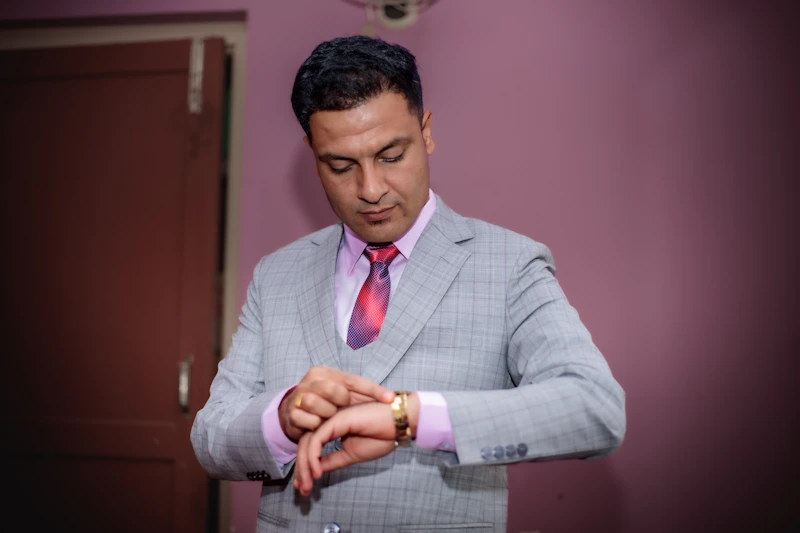 Man in suit checks his wristwatch