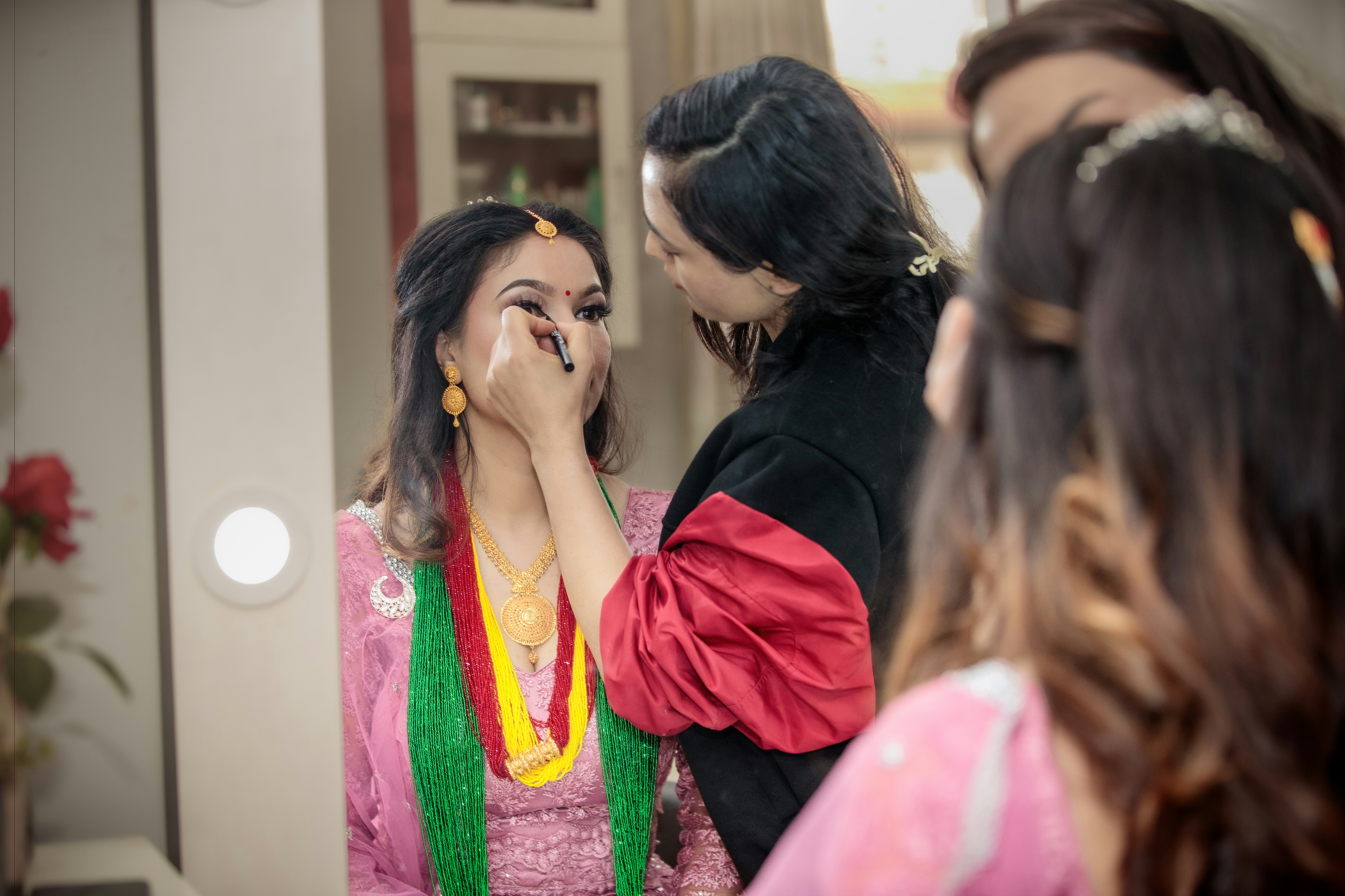 Makeup artist applying makeup to bride