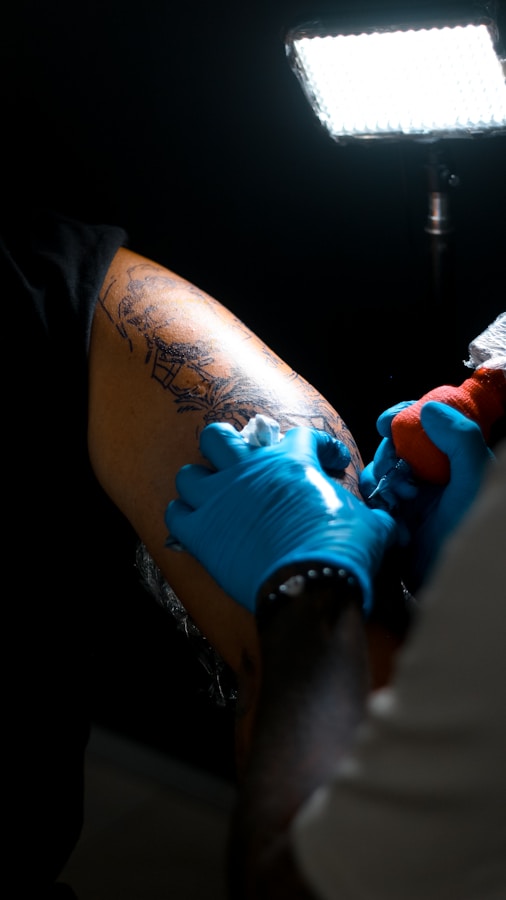 Tatuador aplicando tinta en el brazo de un cliente