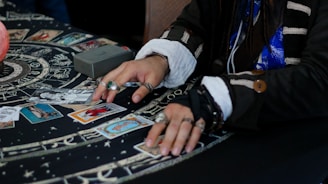 Hands arranging tarot cards on a celestial patterned cloth.