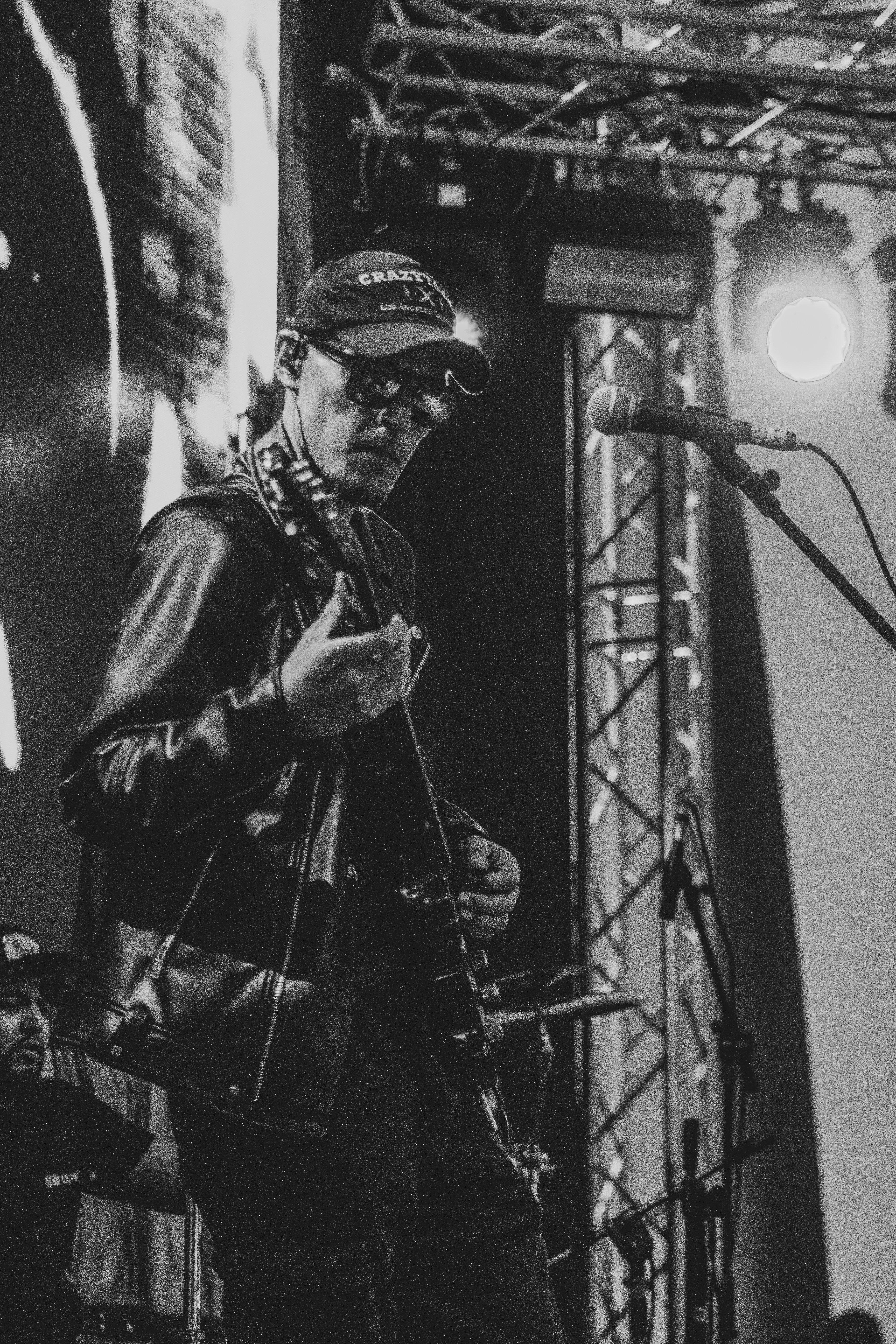 Man playing guitar on stage with sunglasses