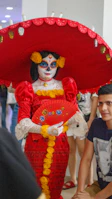 Woman in elaborate red costume and skull face makeup