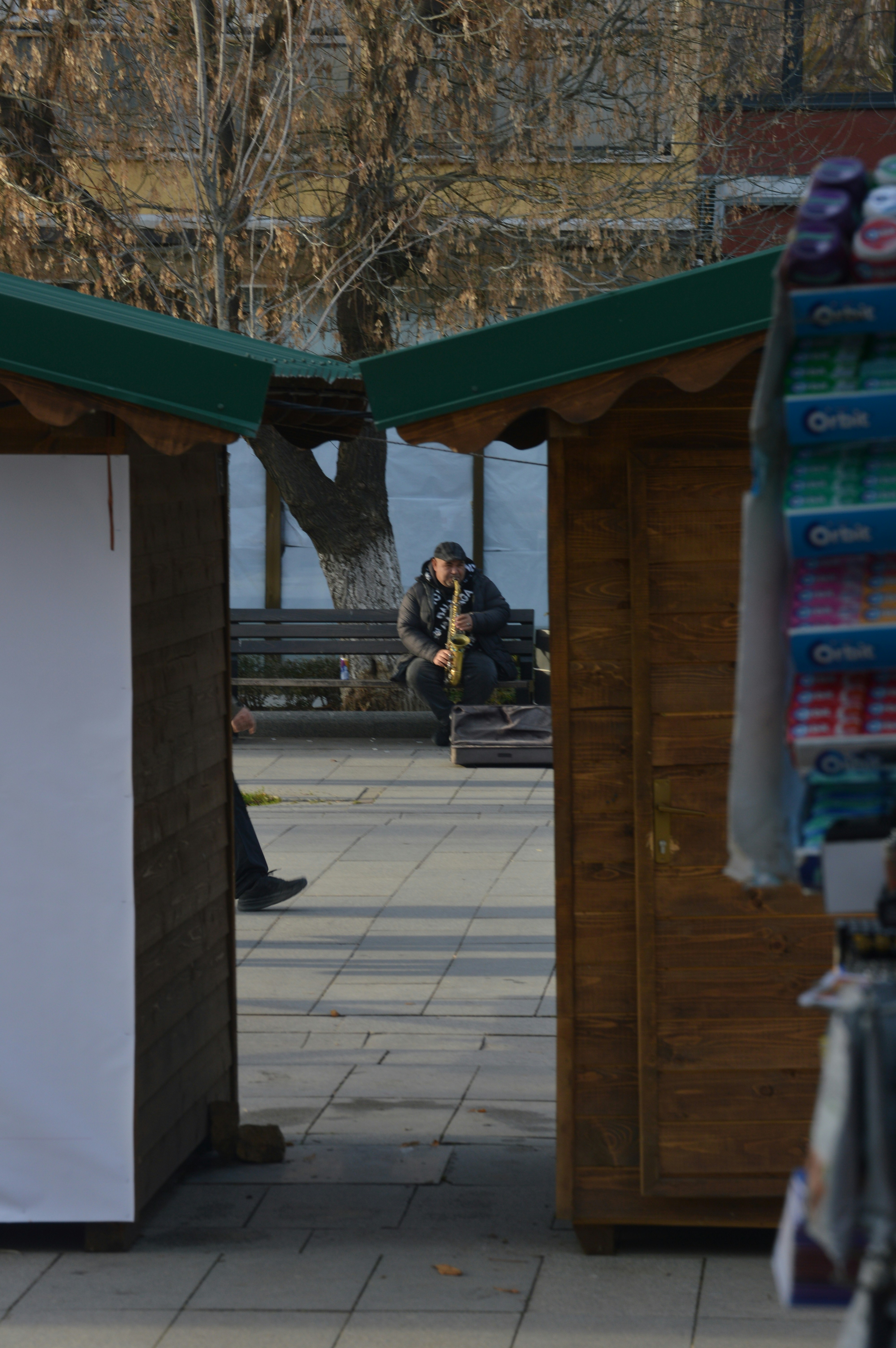 Man playing saxophone on a park bench