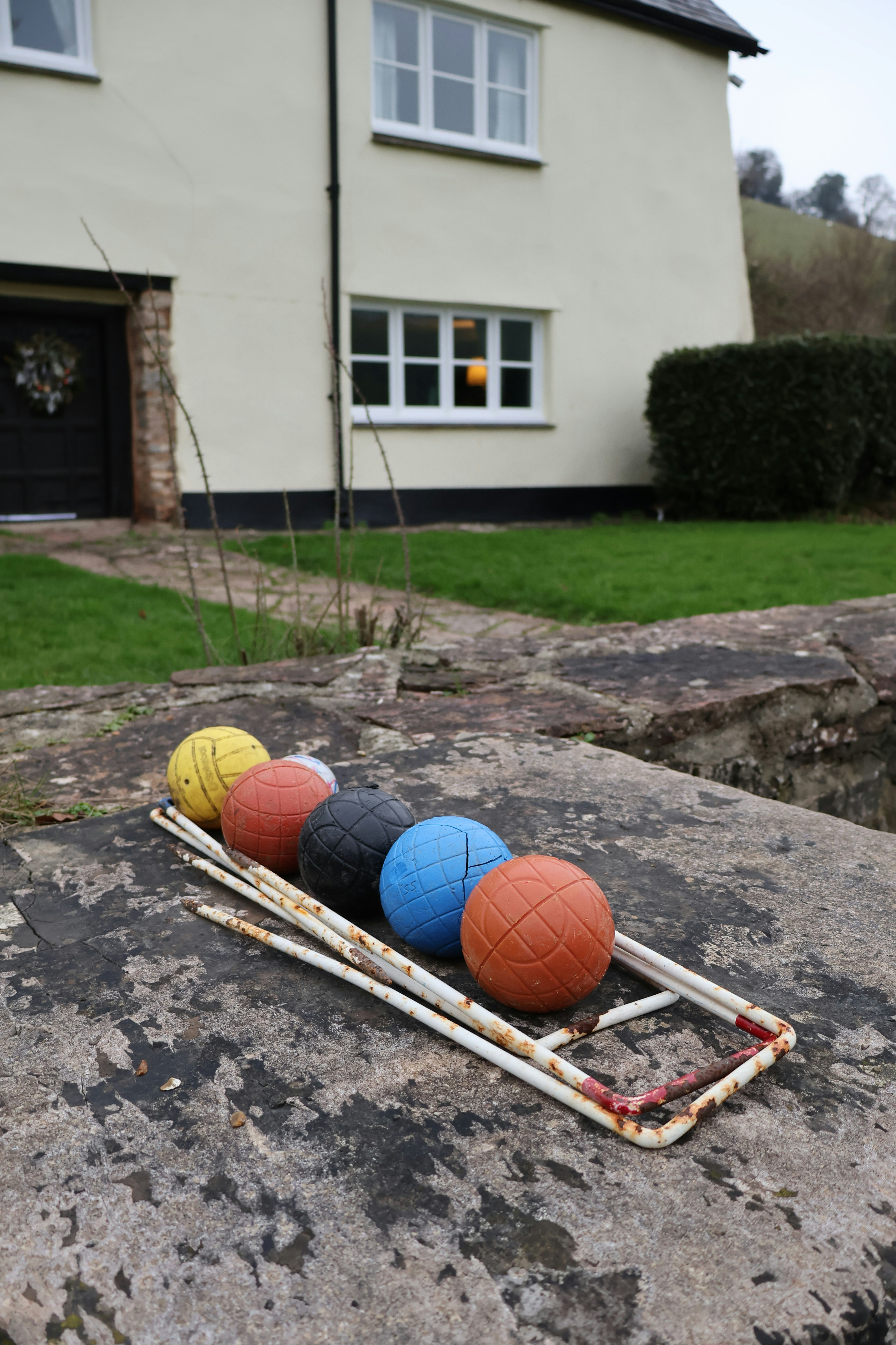 Croquet balls resting on a stone wall