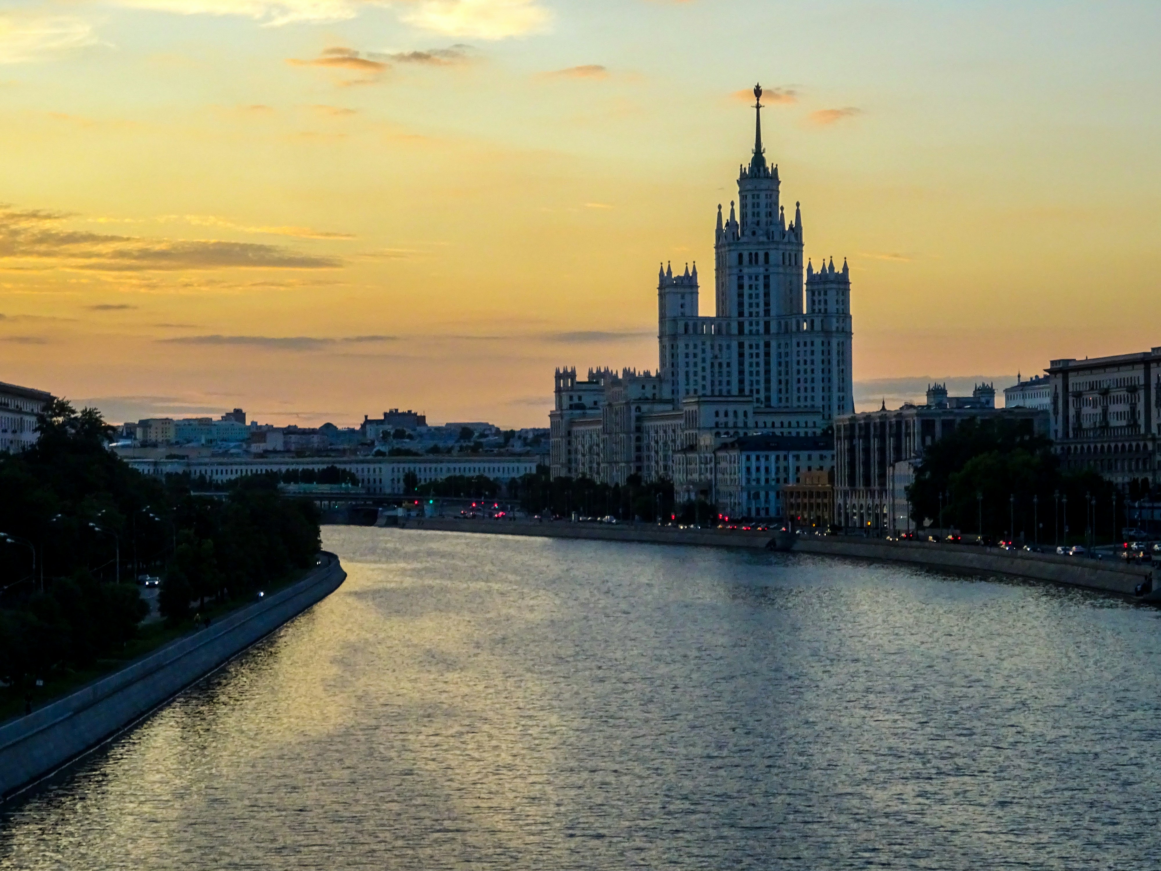 Gratte-ciel sur la rive de la rivière au coucher du soleil