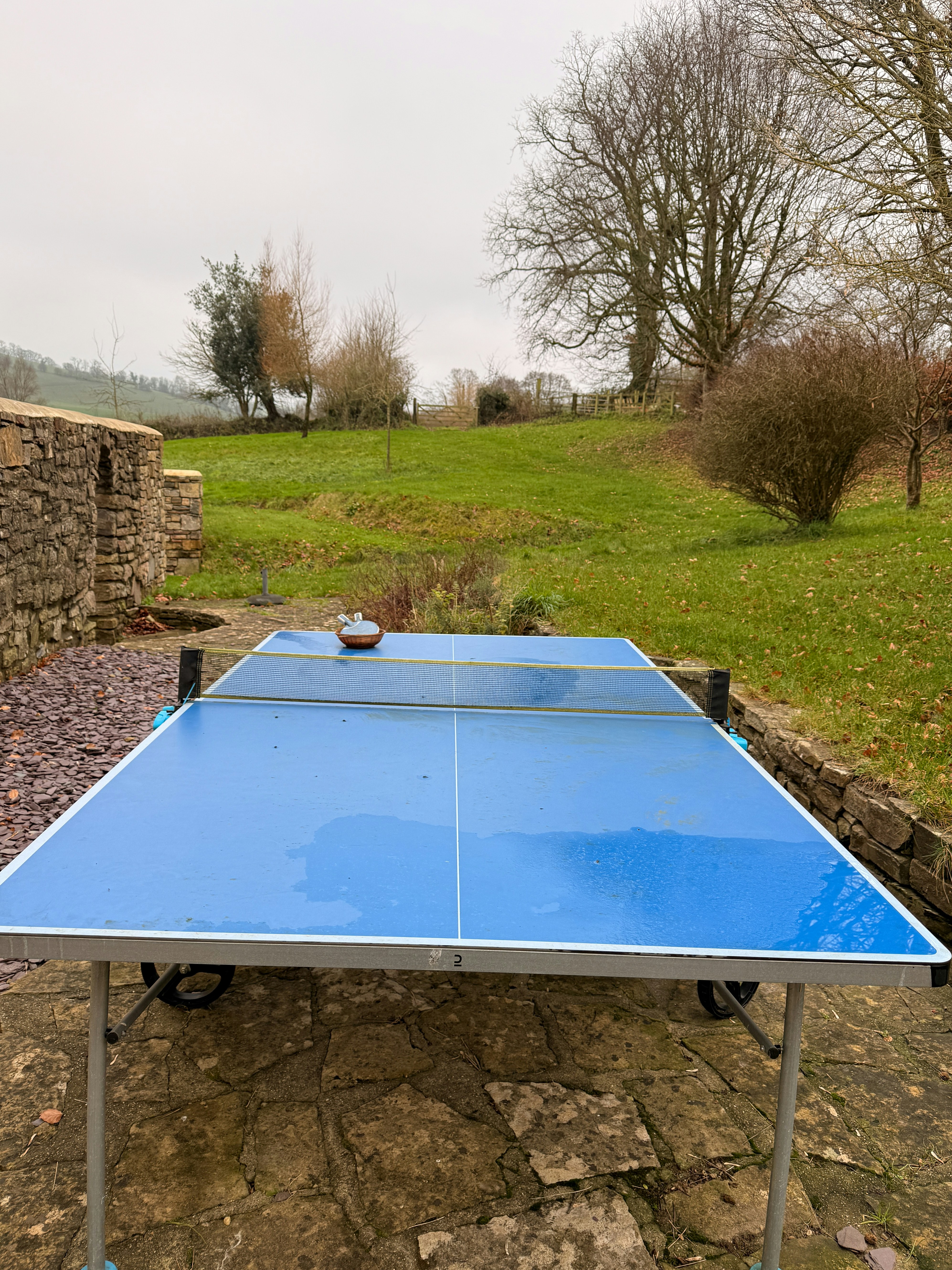 Blue ping pong table on a patio outdoors