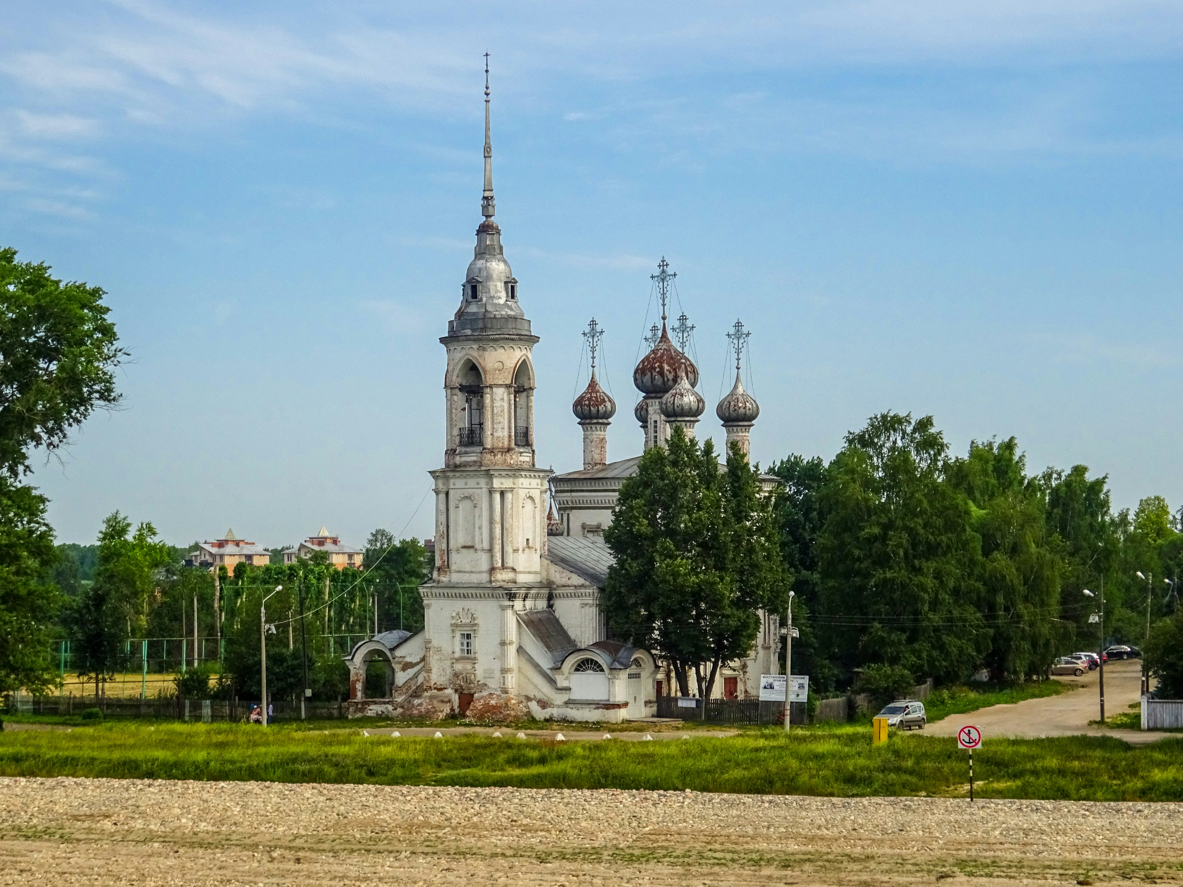 White church with domed roofs and trees