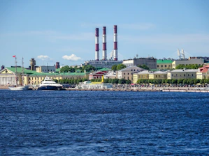 City skyline with industrial chimneys and waterfront buildings by water