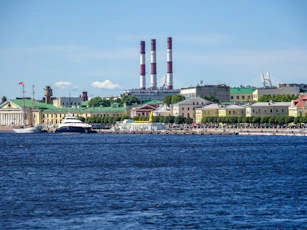 City skyline with industrial chimneys and waterfront buildings by water
