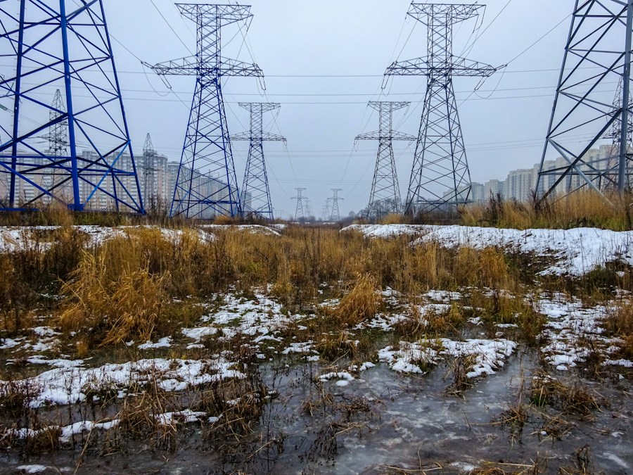 Lignes électriques à haute tension traversant un paysage enneigé et givré en plein hiver