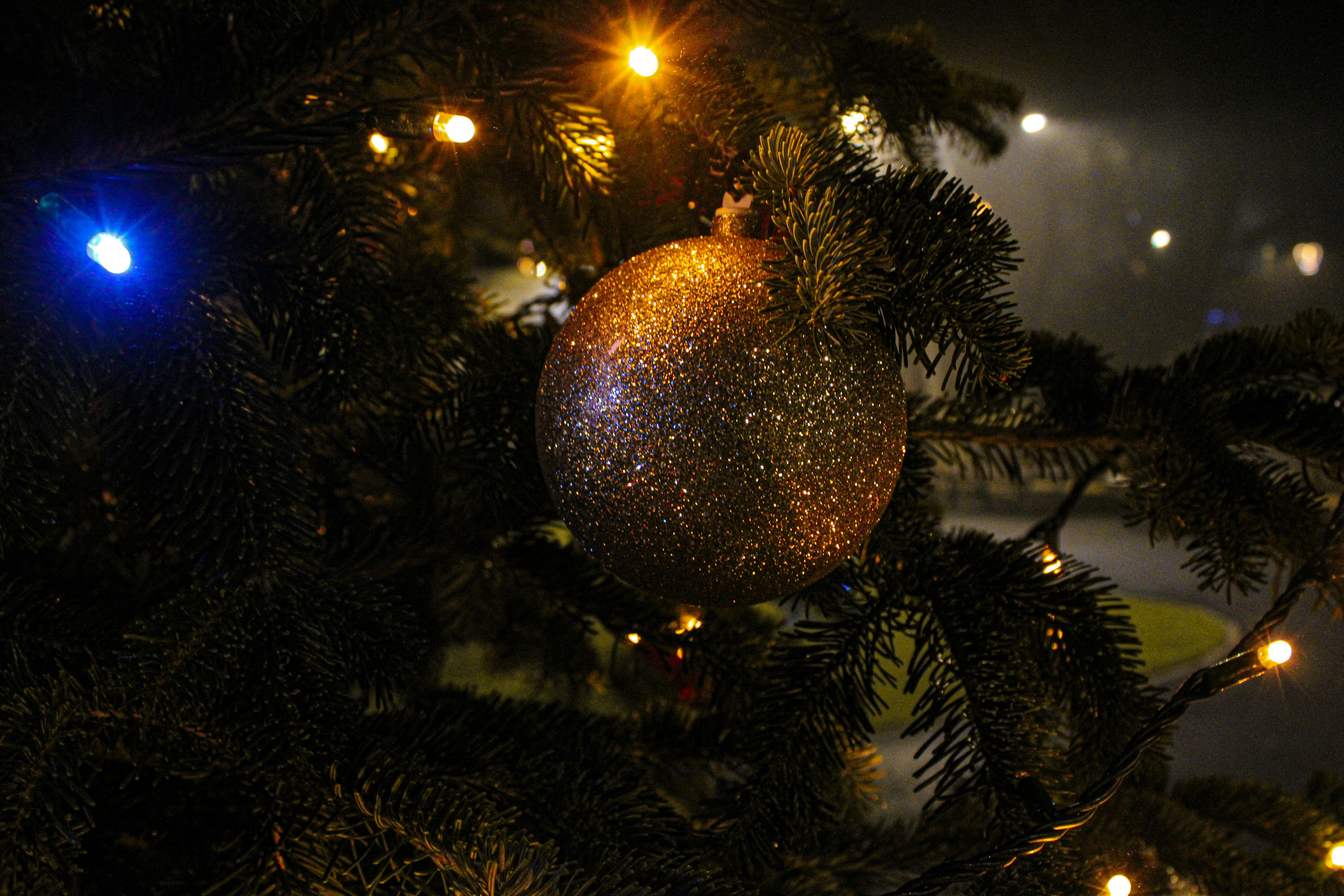Close-up of a glittery ornament on a christmas tree