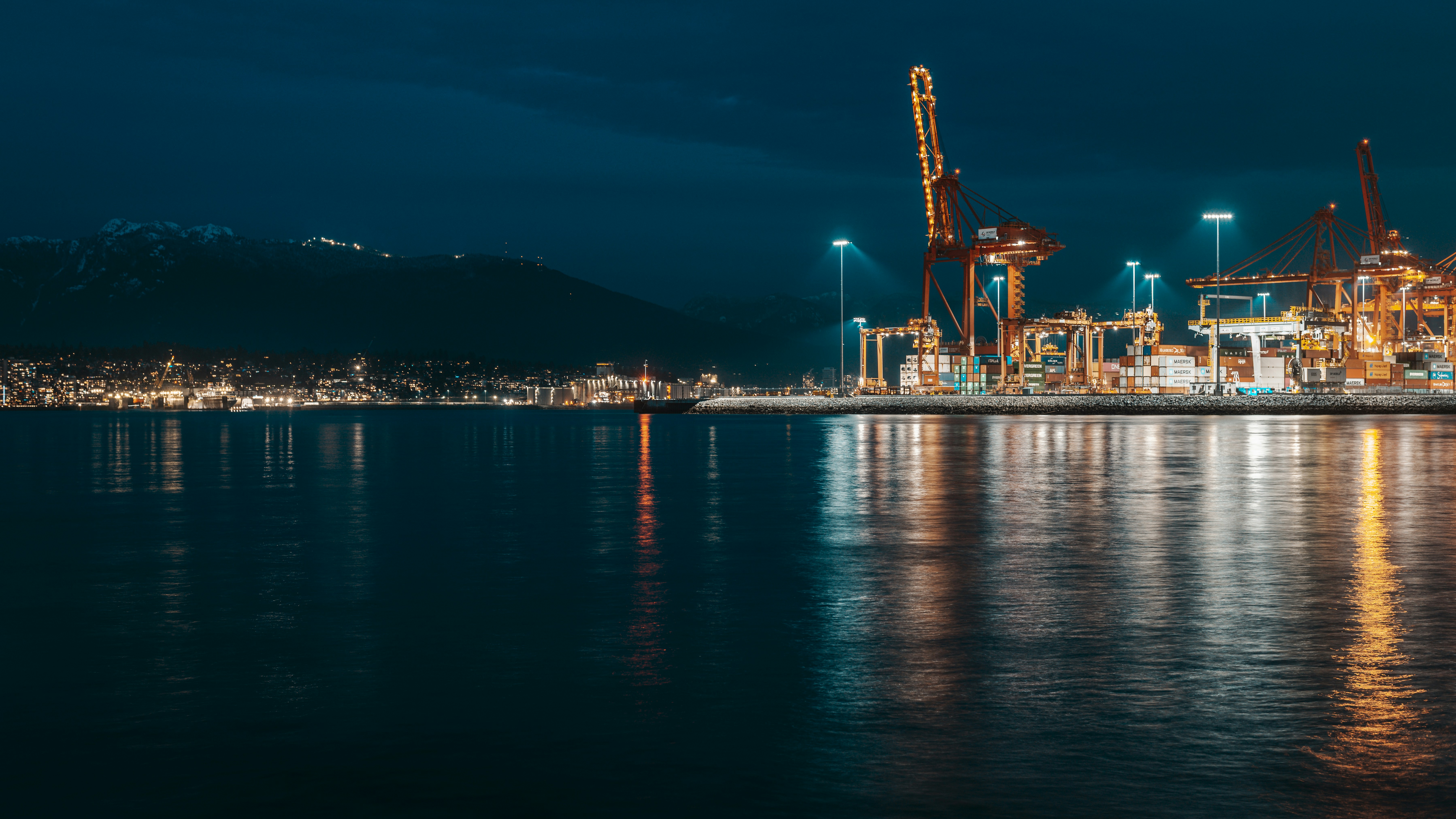 Industrial port with cranes illuminated at night