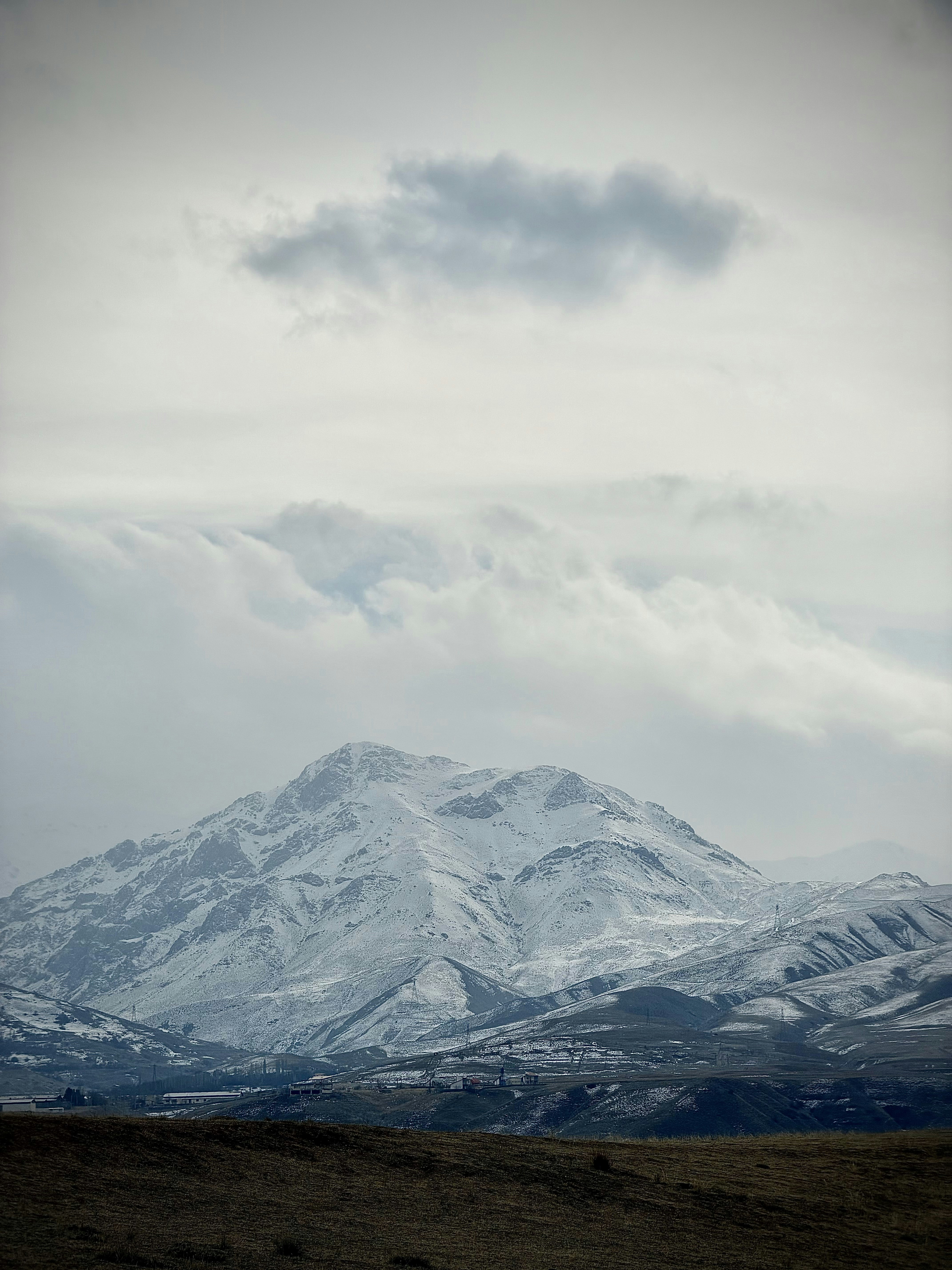 曇り空の下、雪に覆われた山脈