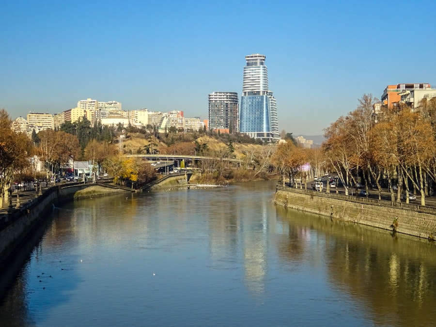 The Mtkvari River winding through Tbilisi with modern skyline rising in the distance
